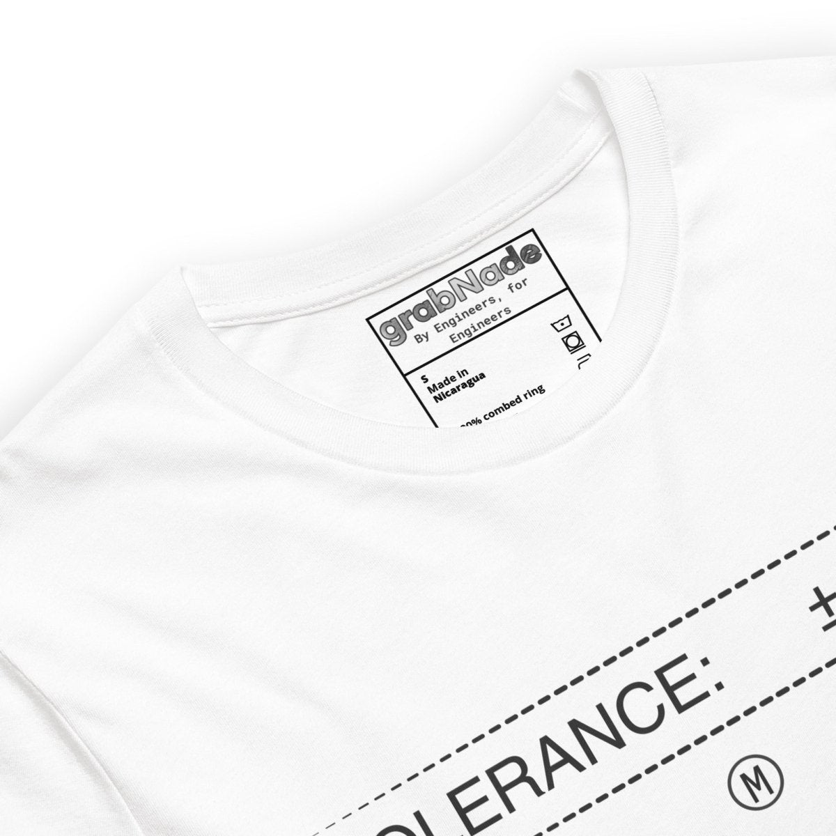 Close up of white t-shirt featuring "TOLERANCE: ±.0002" (M)" blueprint precision engineering graphic.