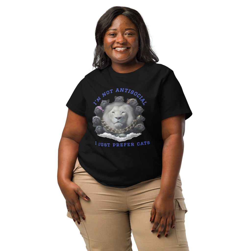 Product mockup. A woman wearing a 2XL black organic cotton t-shirt featuring a bold graphic on the front: a large white lion's head surrounded by black panthers wearing colorful bandanas, arranged in a circle. Above the graphic is the phrase 'I'M NOT ANTISOCIAL' and below it reads 'I JUST PREFER CATS' in blue capital letters.