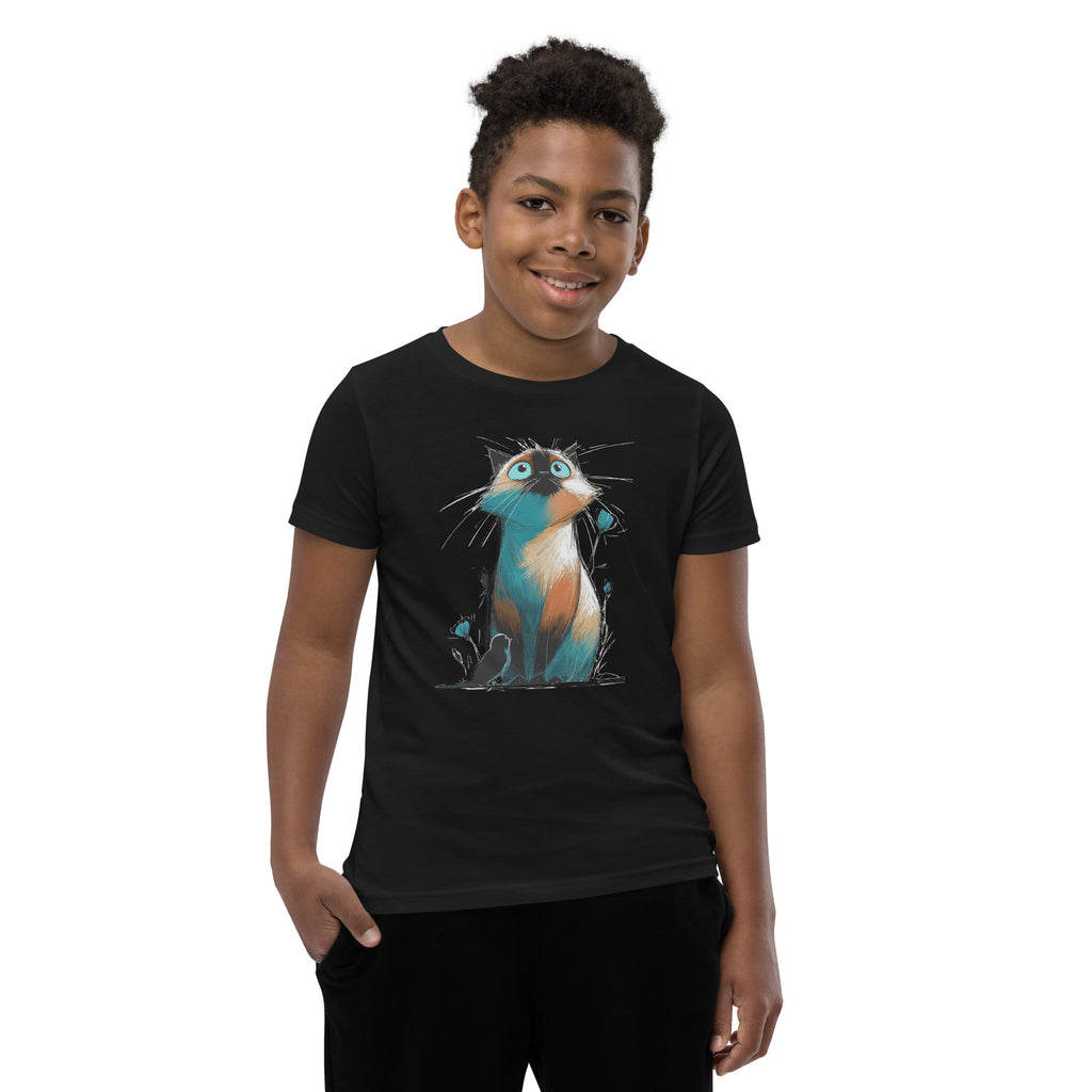 Product mockup. A young boy wearing a black t-shirt with a lively, sketch-style illustration of a wide-eyed cat shaded in teal and orange, sitting among stylized buds, while a small black bird perches at its paws. The image is set against a plain studio background, with the whimsical design clearly displayed on the shirt.