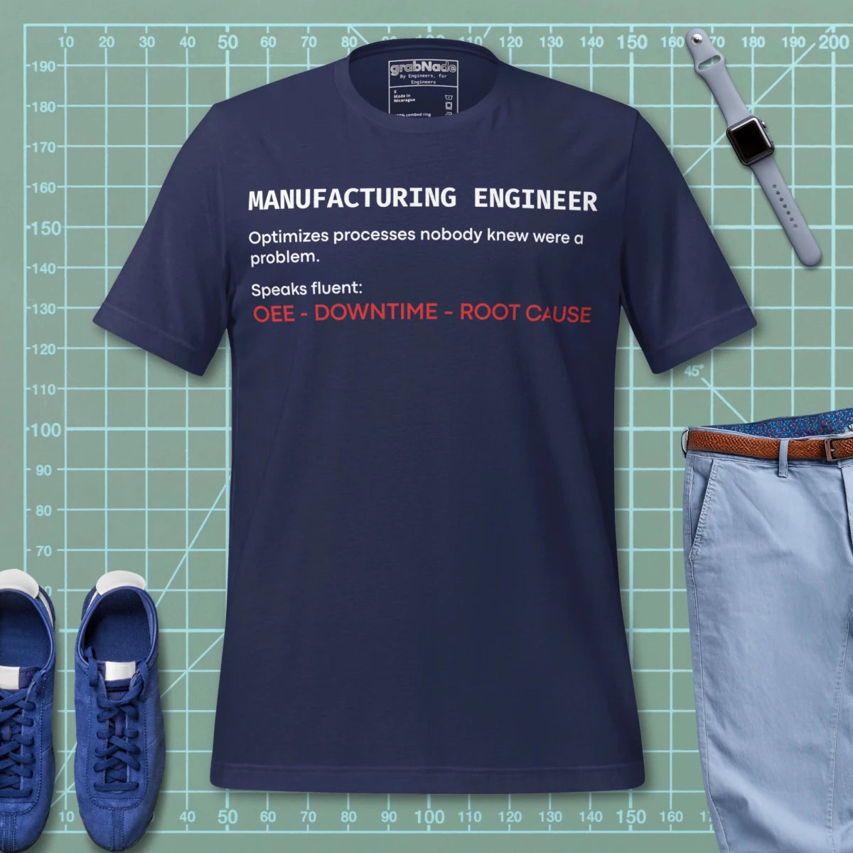 Navy t-shirt with "Manufacturing Engineer" definition featuring OEE and root cause terminology.
