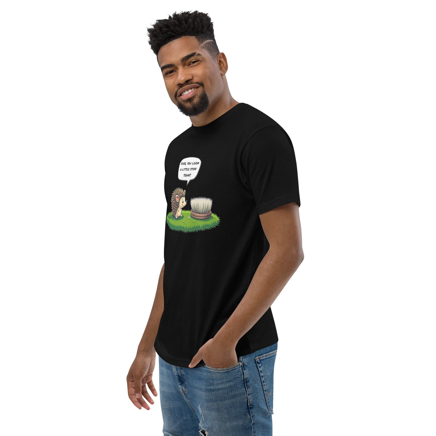 Product mockup. Man standing at an angle in a black t-shirt and jeans, featuring a cartoon hedgehog talking to a brush, on the front.