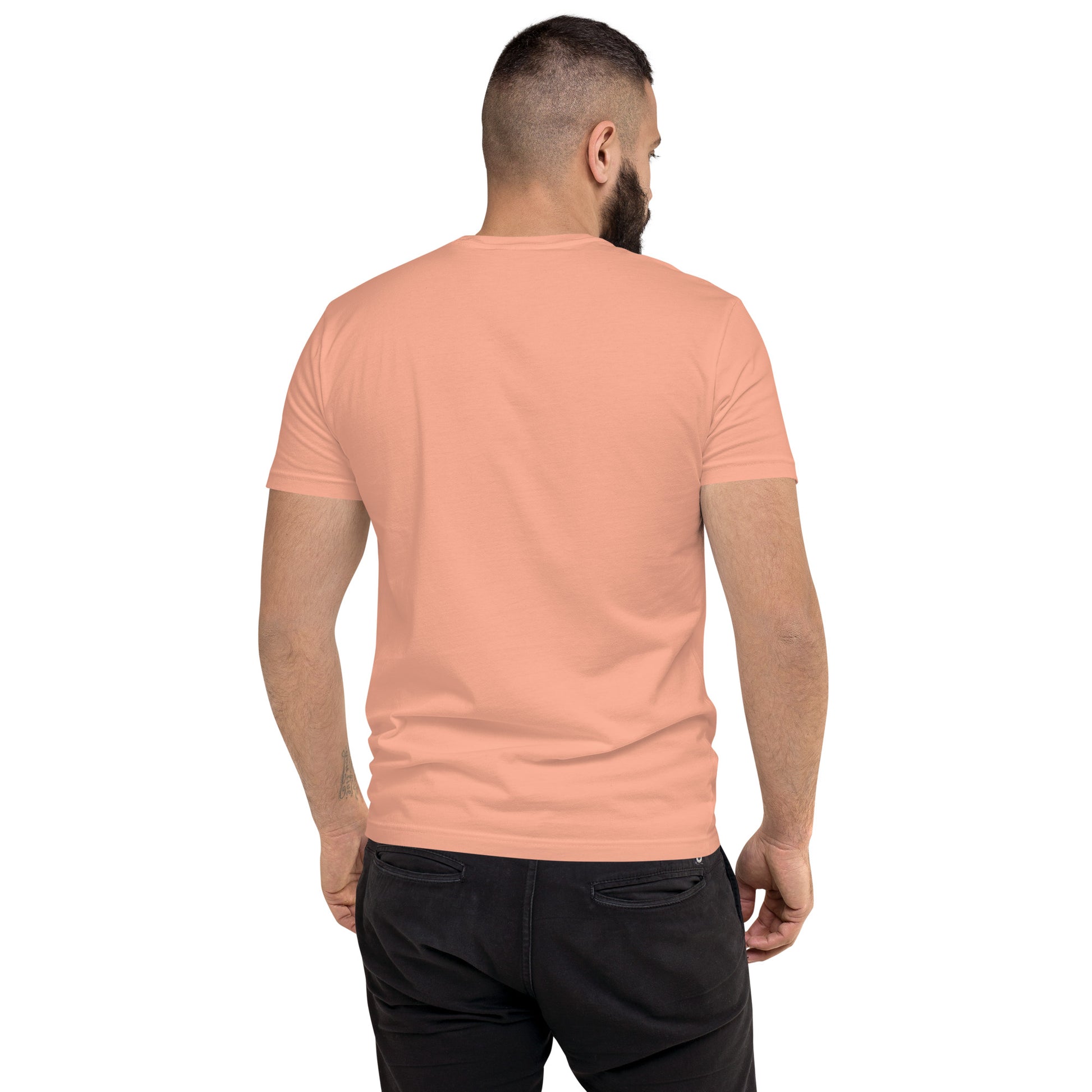 Product mockup. Man with short hair and beard wearing a plain desert pink fitted t-shirt and black pants, back view.