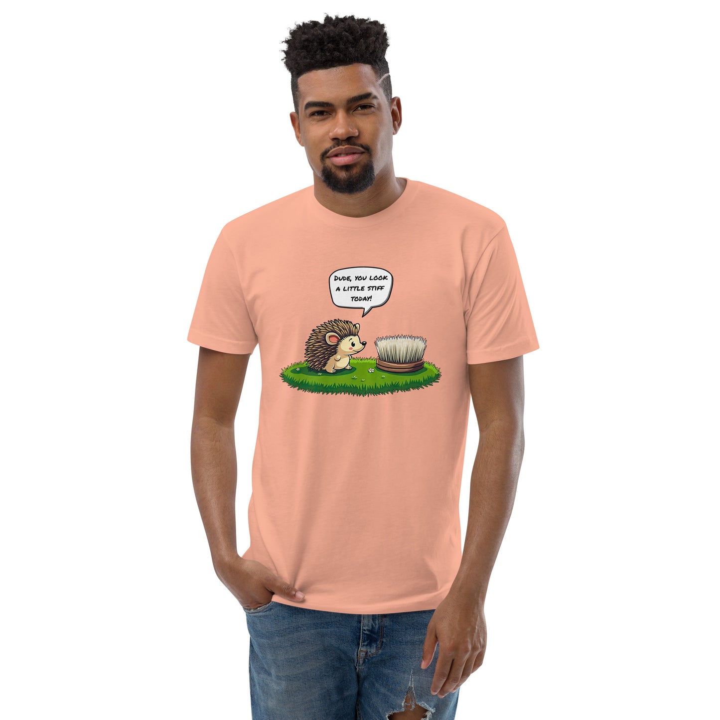 Product mockup. Desert pink t-shirt on a hanger printed with a cartoon hedgehog talking to a round brush and the caption, "Dude, you look a little stiff today!"