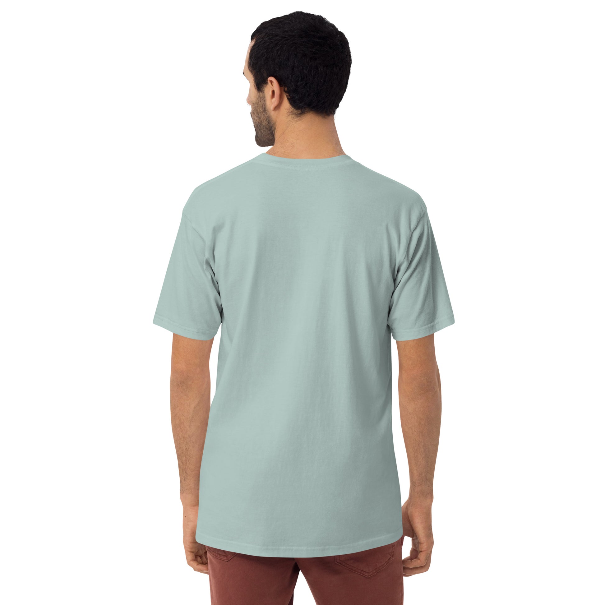 Product mockup. Man with short dark hair and beard shown from behind, wearing an agave-colored premium heavyweight t-shirt and dark pants, plus size.