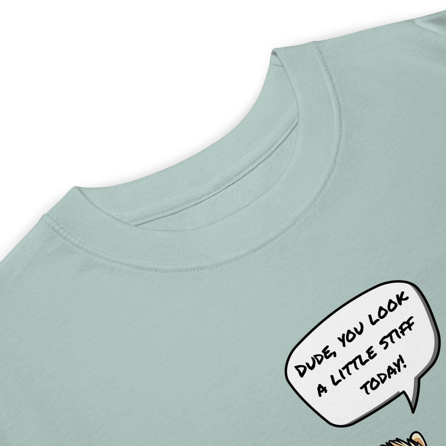 Close-up of the grabNade Men's Relaxed Heavyweight Tee in light blue premium cotton, featuring a comic speech bubble: "Dude you look a little stiff today." Only the top portion and part of a cartoon character are visible.