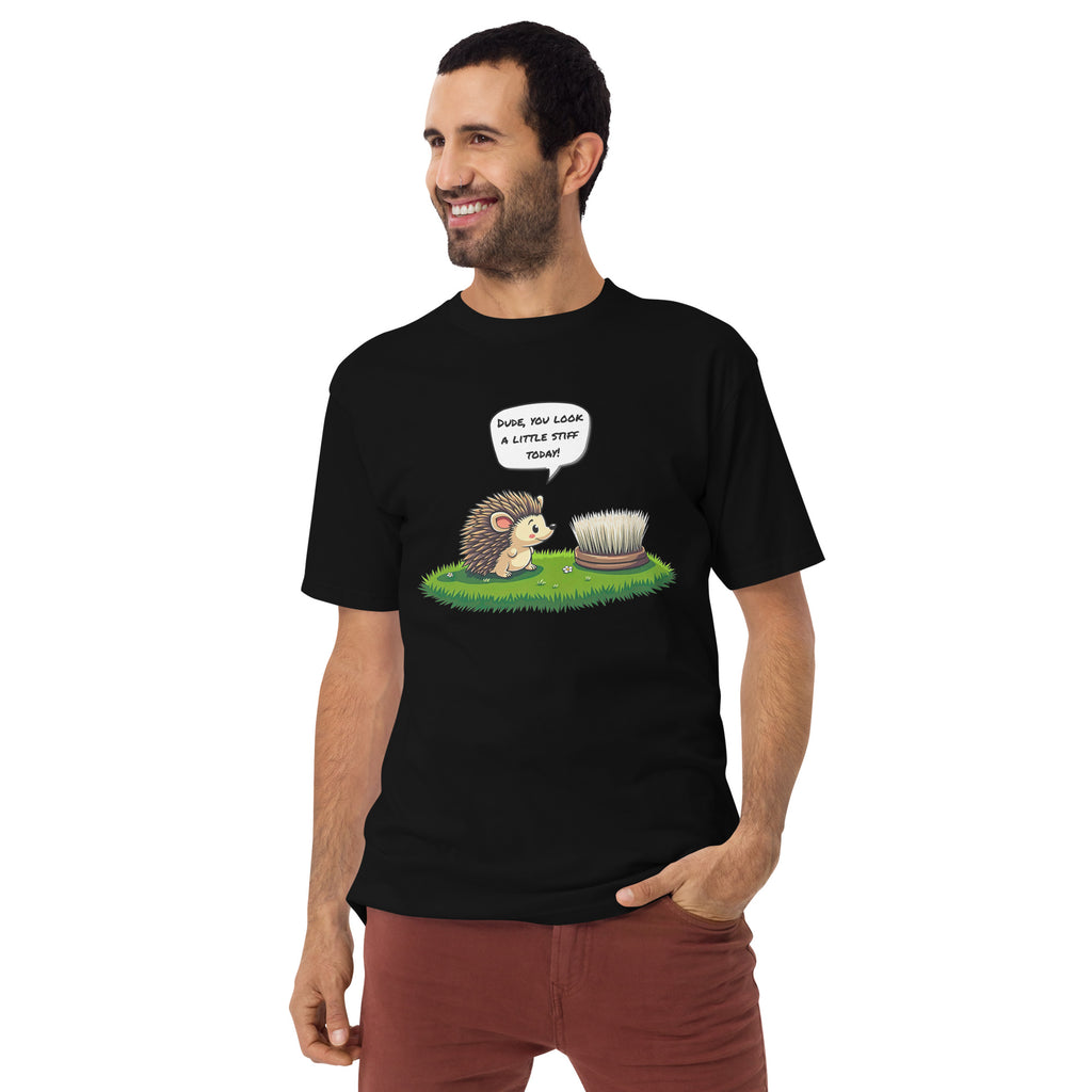 Product mockup. Plus-size man standing in a black heavyweight t-shirt featuring a cartoon hedgehog talking to a round brush and the caption "Dude, you look a little stiff today!"