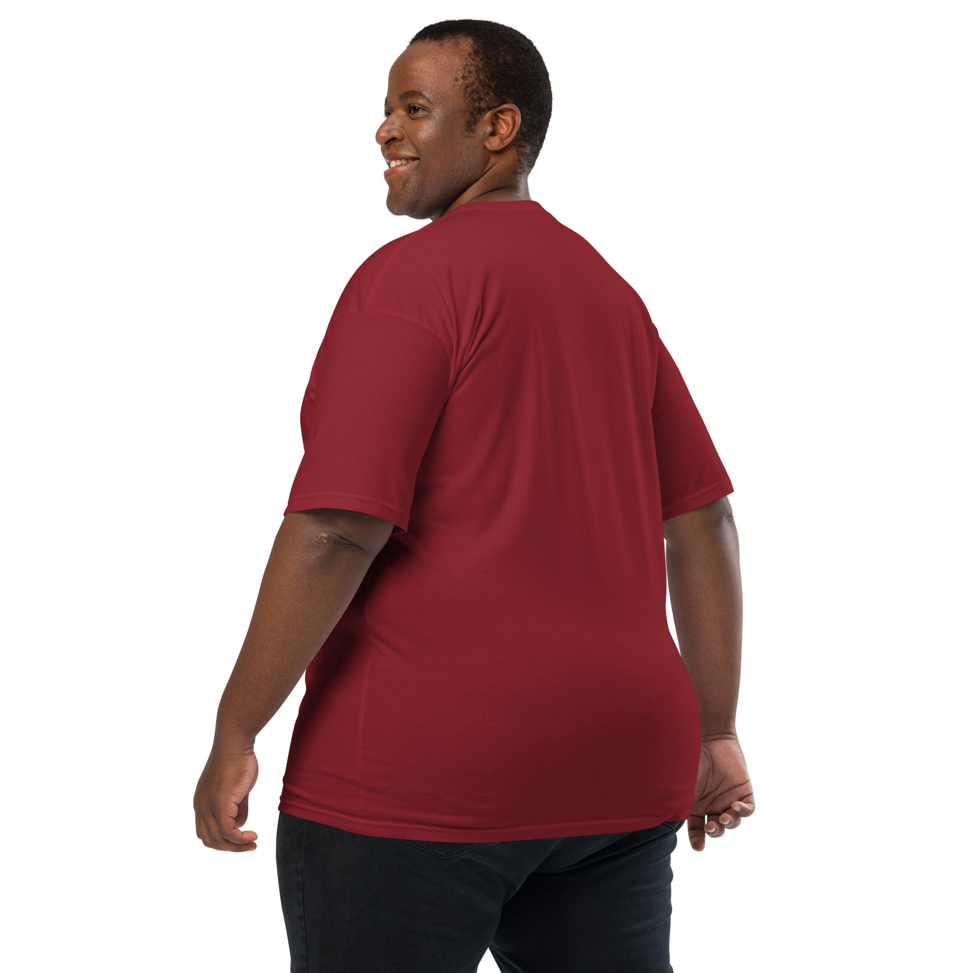 Product mockup. Man with short curly hair shown from behind, wearing a plain brick-red heavyweight t-shirt and brick-colored pants.
