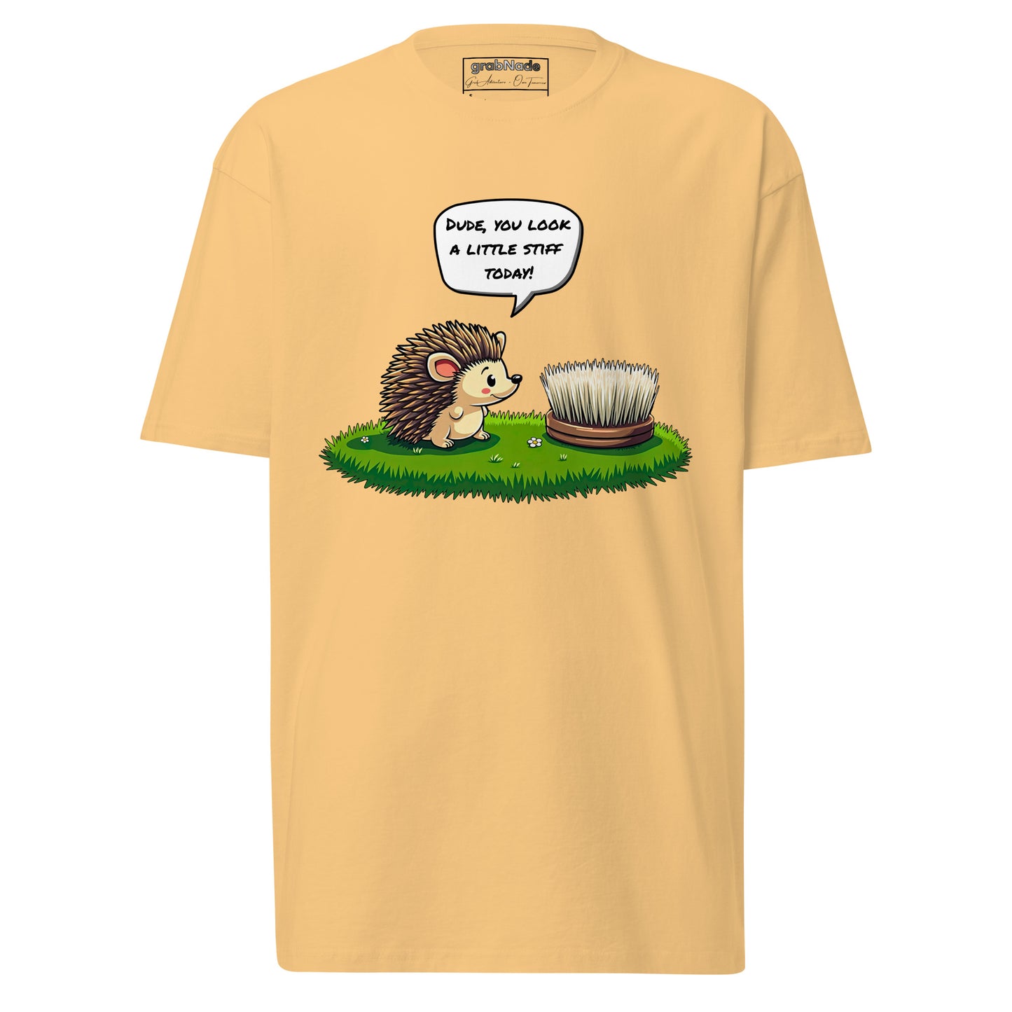 Product mockup. Man with short curly hair and an earring standing at an angle in a pale yellow t-shirt and brick-colored pants, with a cartoon hedgehog talking to a brush and the caption "Dude, you look a little stiff today!"