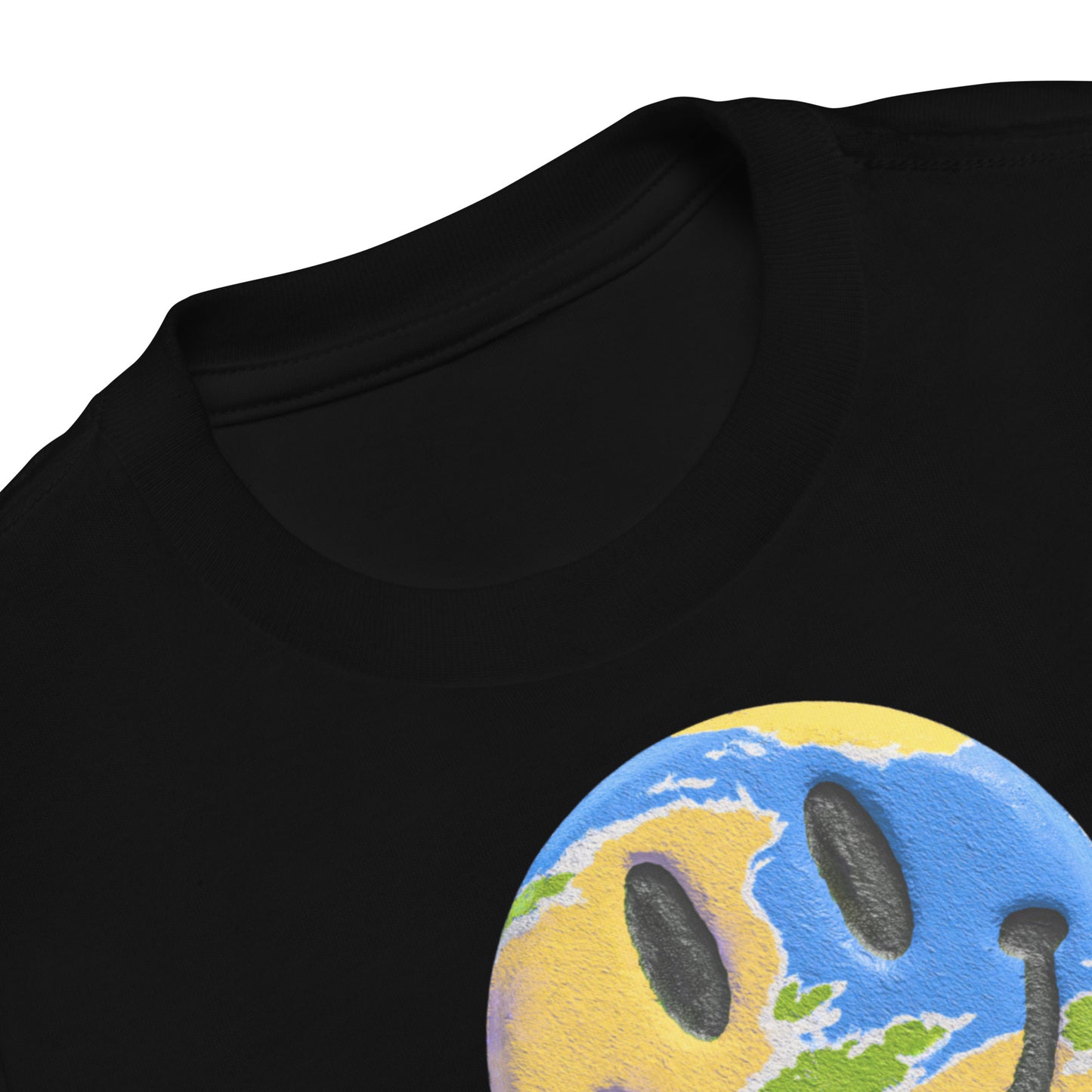 Product mockup. Close-up of a black t-shirt collar, showing a partial print of a blue and yellow smiley face with a world map design on the chest.