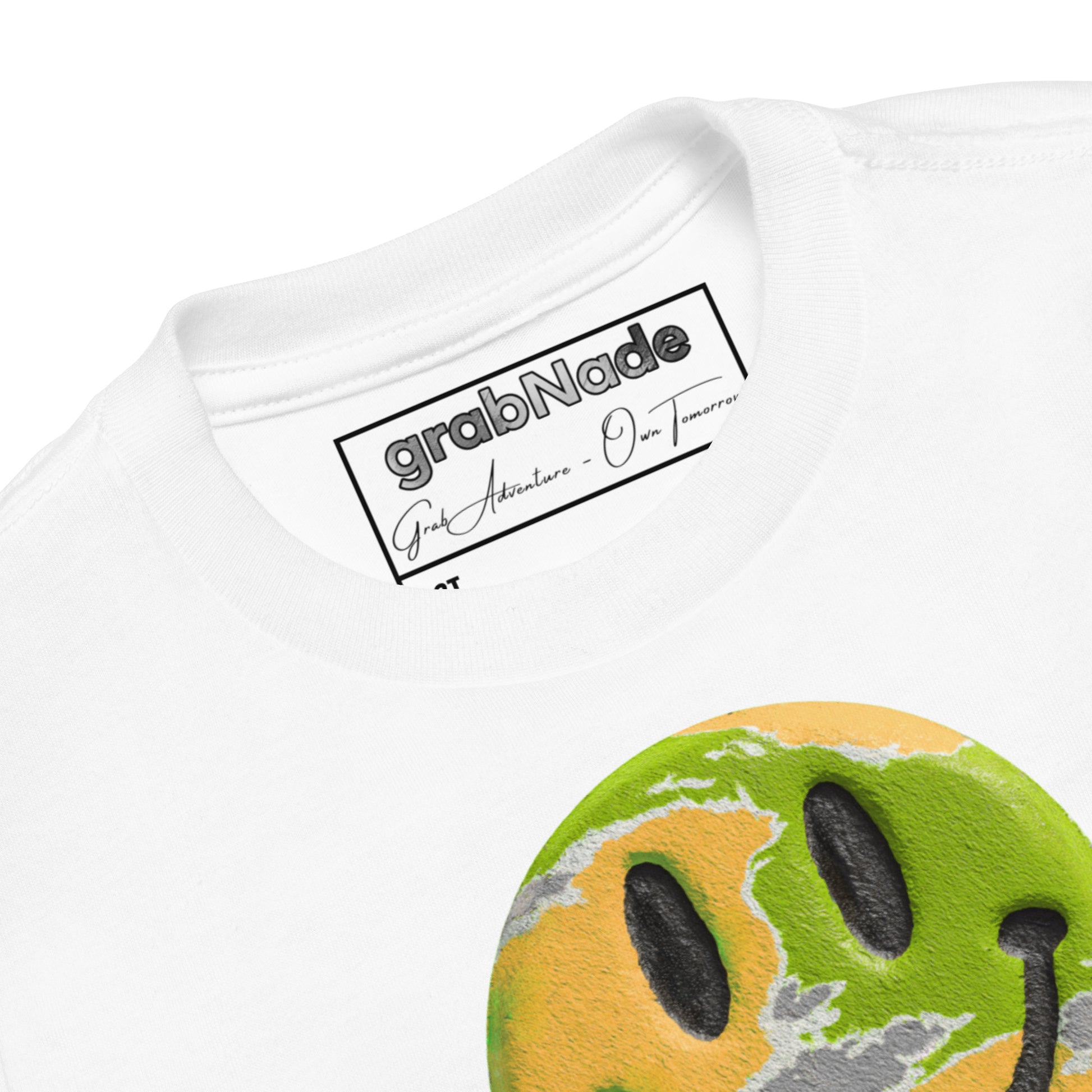 Product mockup. Close-up of a white t-shirt collar, partial blue and yellow smiley face graphic, showing a printed grabNade label.