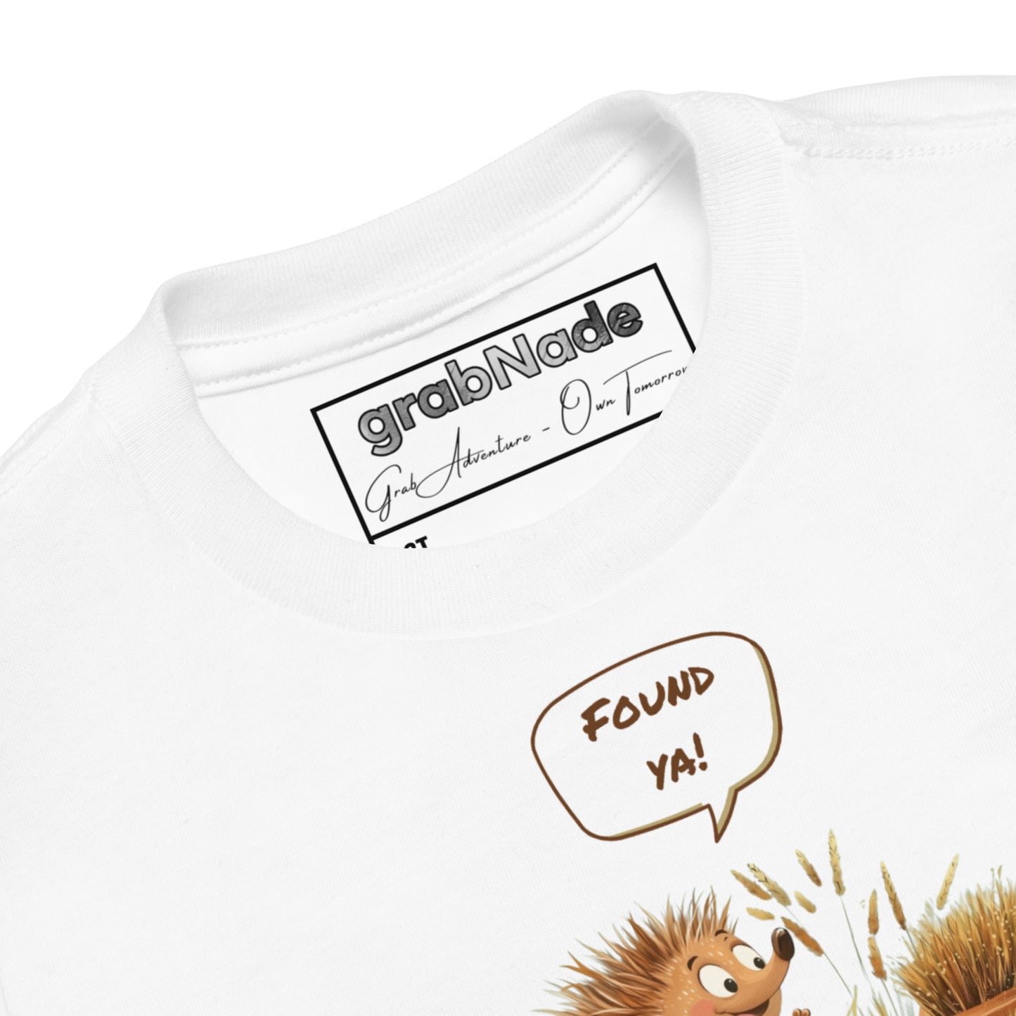 Product mockup. Close-up of a white t-shirt collar, partial blue and yellow smiley face graphic, showing a printed grabNade label.