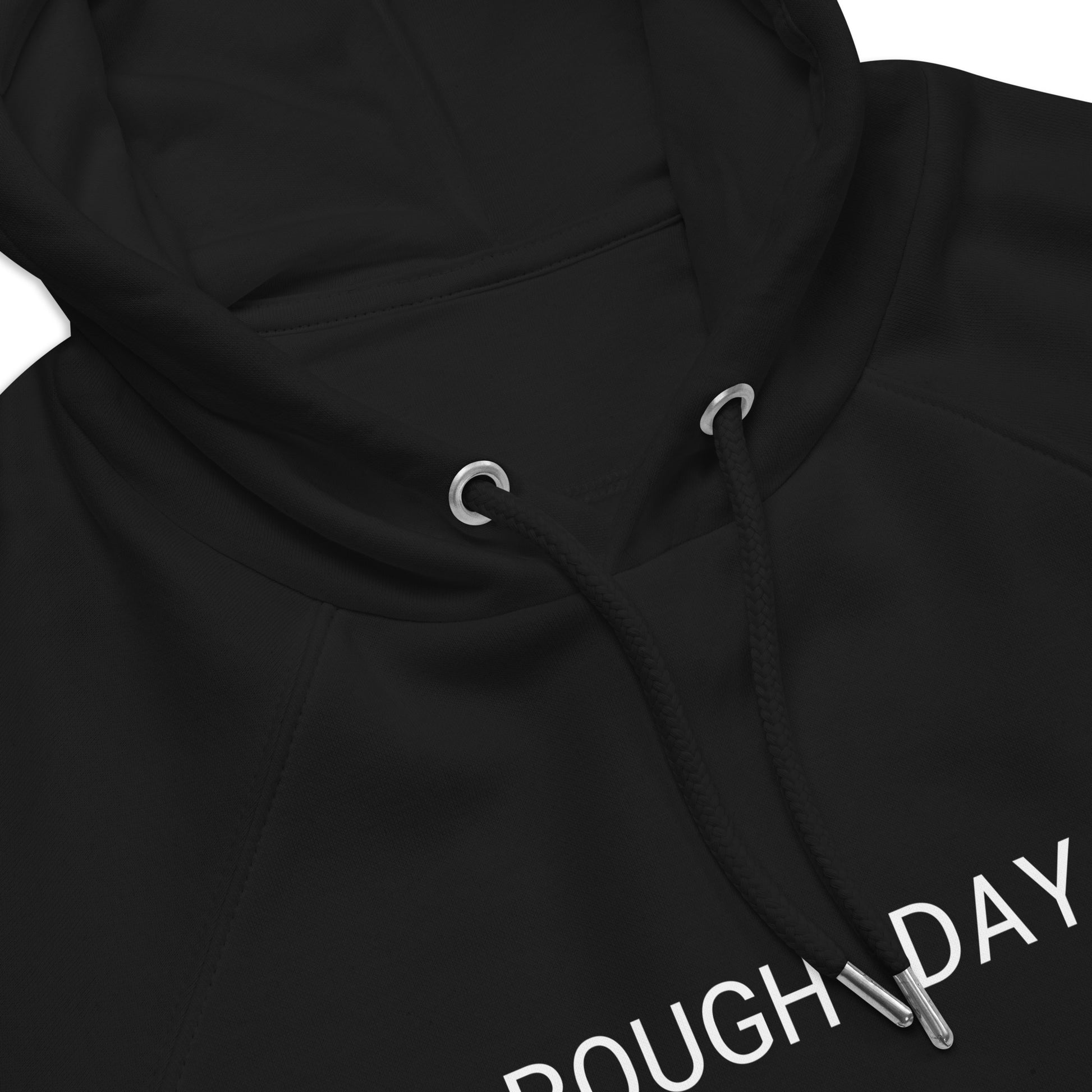 Closeup of top front view of black hoodie with partial view of the white text "Rough Day".