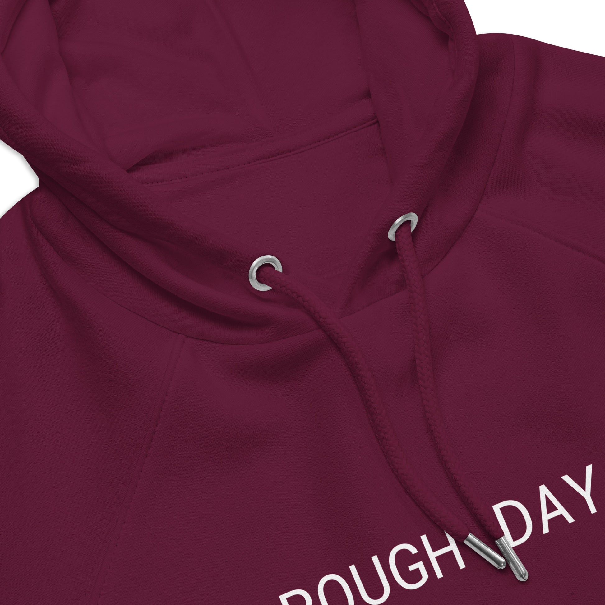 Closeup of top front view of red hoodie with partial view of the white text "Rough Day".