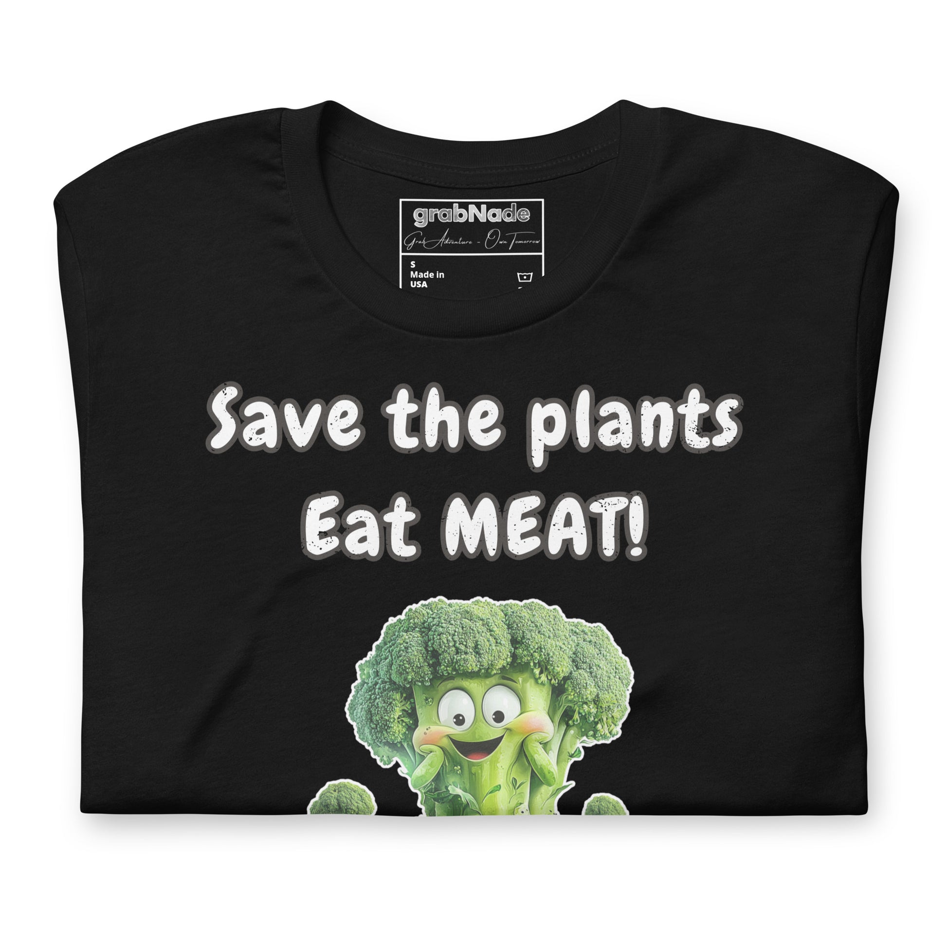 Product mockup. Black t-shirt with bold white text “Save the plants, Eat MEAT!” and a smiling cartoon broccoli character.