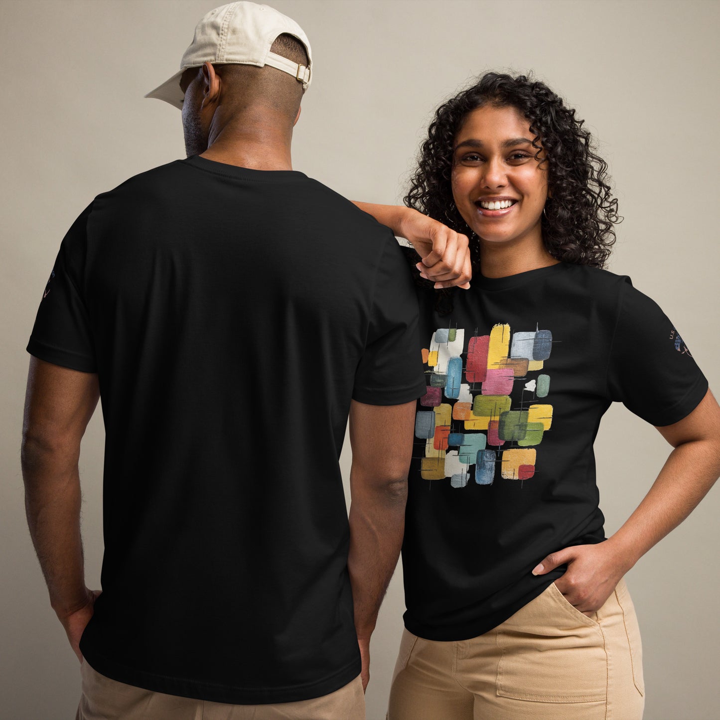 Product mockup. Two people; woman in a black t-shirt with a colorful block pattern on the chest, man in a plain black t-shirt.