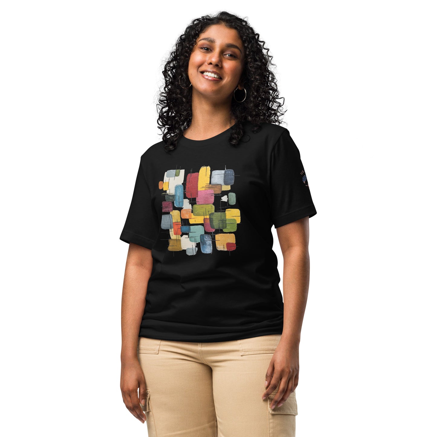 Product mockup. Smiling woman in beige pants wearing a black t-shirt with a colorful geometric rectangular block pattern in the center.
