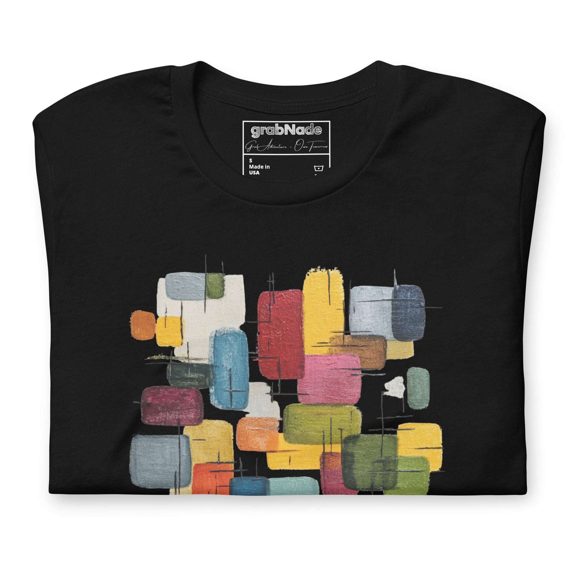 Product mockup. Black t-shirt, neatly folded, showing a colorful abstract geometric block design on the chest.
