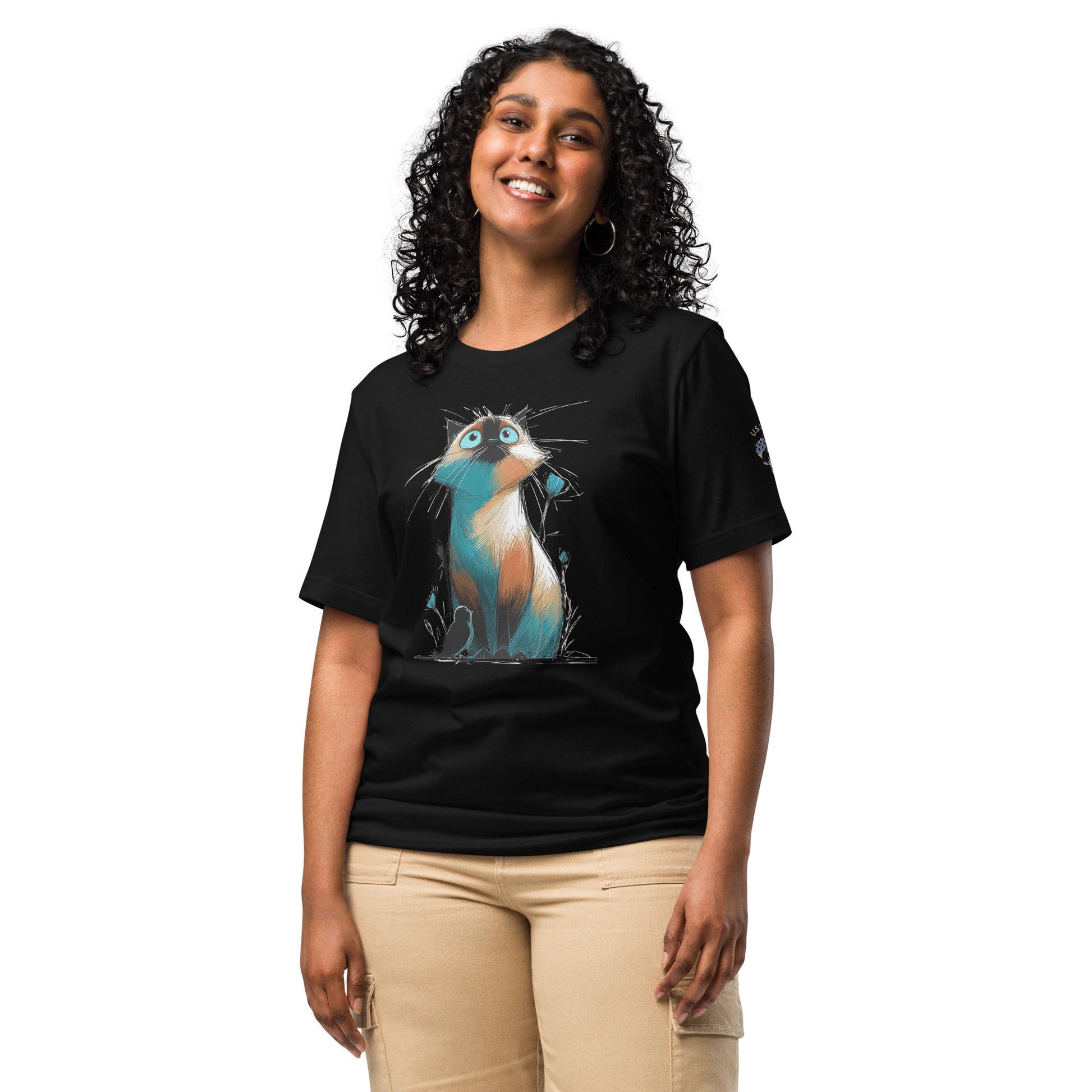 Product mockup. A woman stands wearing a black t-shirt featuring a colorful, stylized cartoon cat with large blue eyes looking upward.