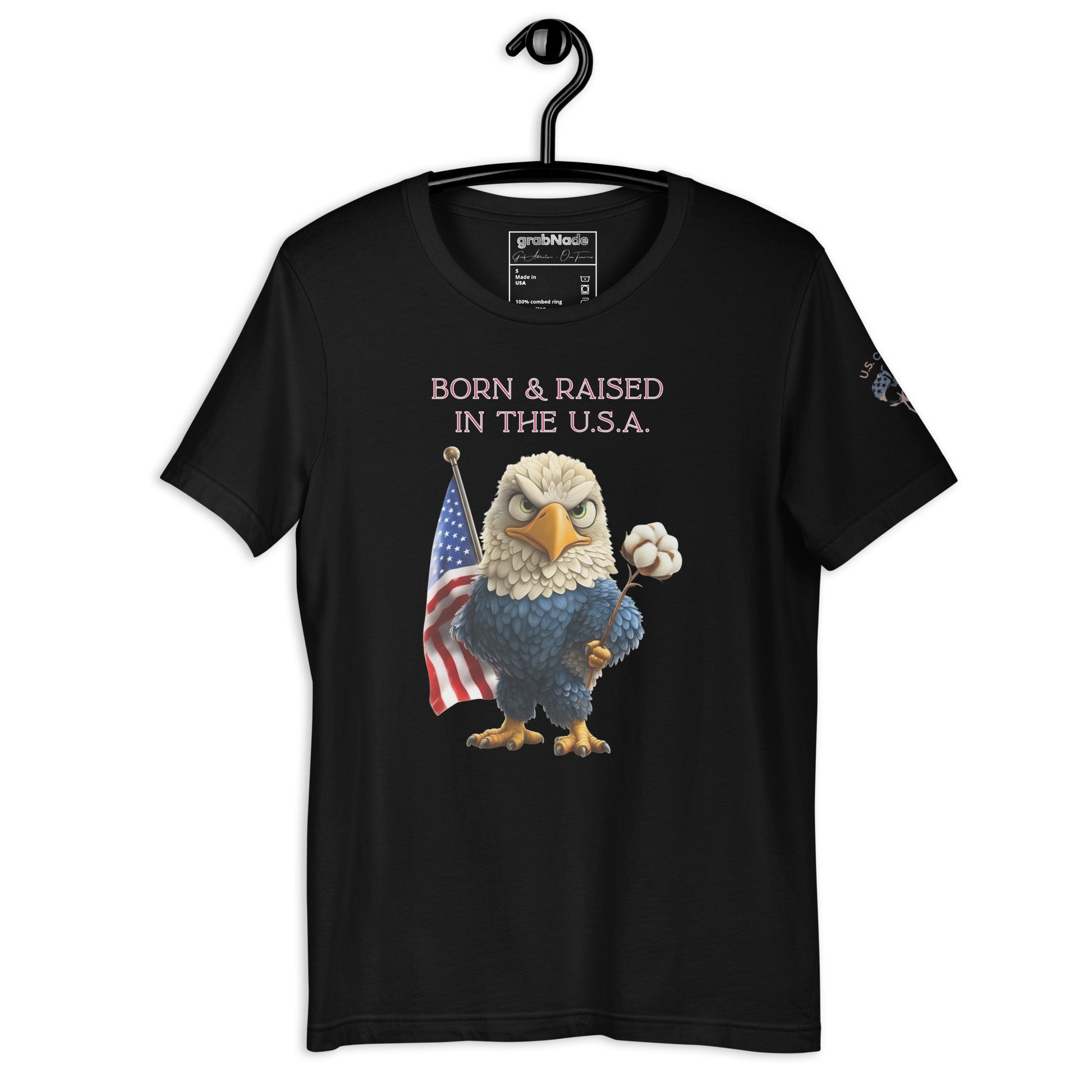 Product mockup. Black t-shirt on a hanger with a cartoon bald eagle holding a cotton flower and standing next to an American flag, above the phrase "Born & Raised in the U.S.A."