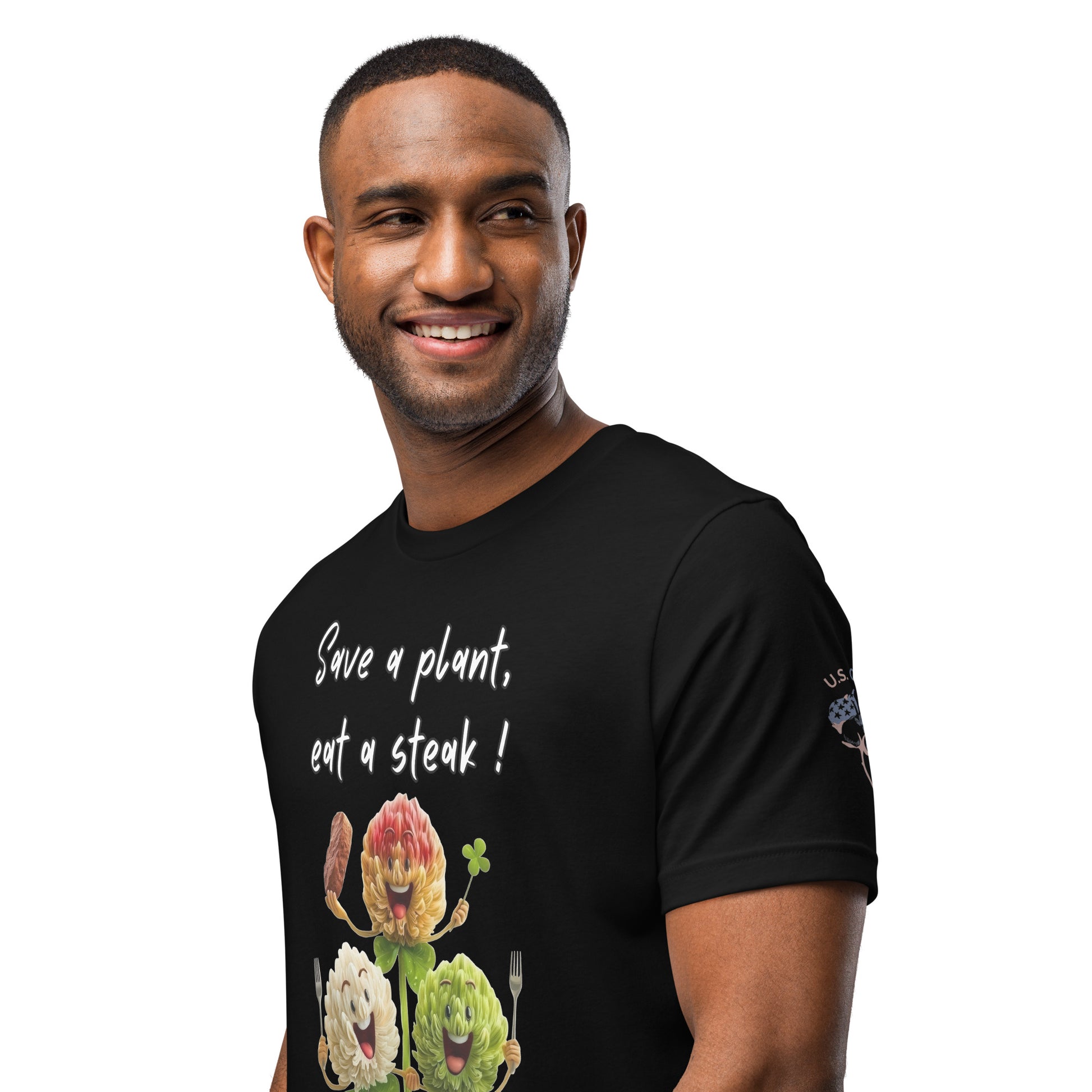 Product mockup. A close-up of a black t-shirt with three humaniod clovers holding utensils and the message "Save a plant, eat a steak!" with a "U.S. Cotton" badge on the sleeve.