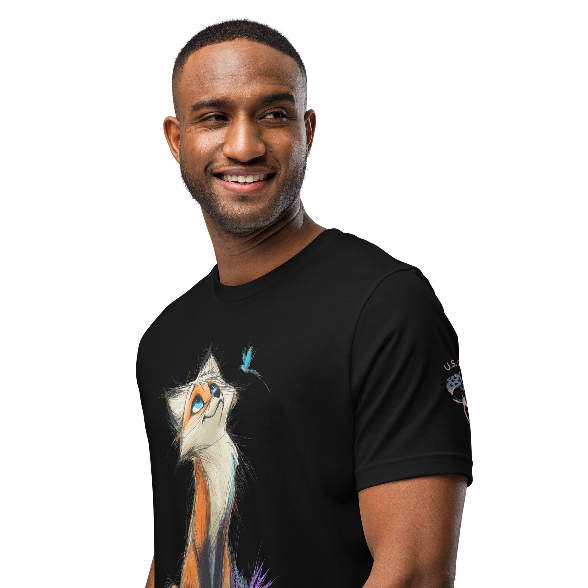 Product mockup. A man wears a black t-shirt with a stylized orange and white cat gazing up at a blue bird, and a "U.S. Cotton" patch on the sleeve.