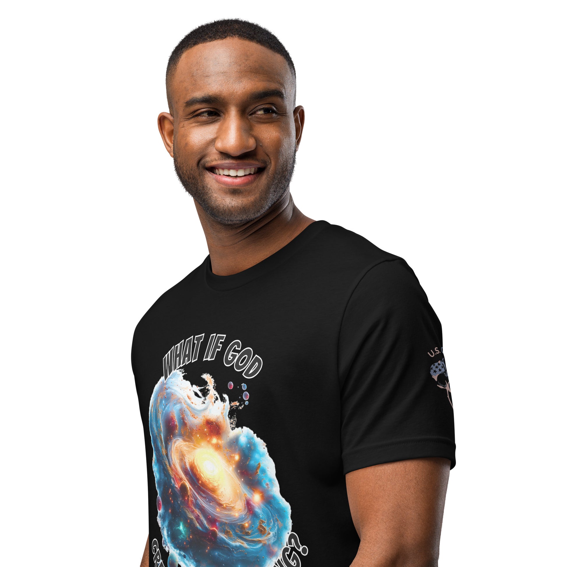 Product mockup. A man wears a black t-shirt with a glowing galaxy and the phrase "WHAT IF GOD CREATED THE BIG BANG?" above, plus a "U.S. Cotton" patch on the sleeve.
