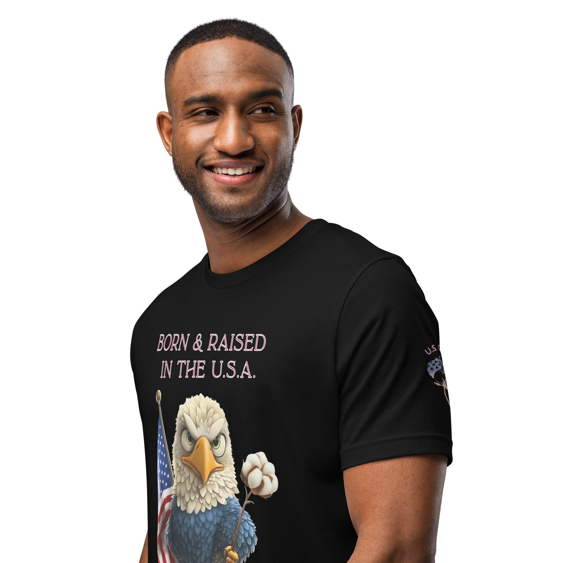 Product mockup. A man models a black t-shirt featuring a cartoon bald eagle holding a cotton boll and the US flag, with the text "BORN & RAISED IN THE U.S.A."