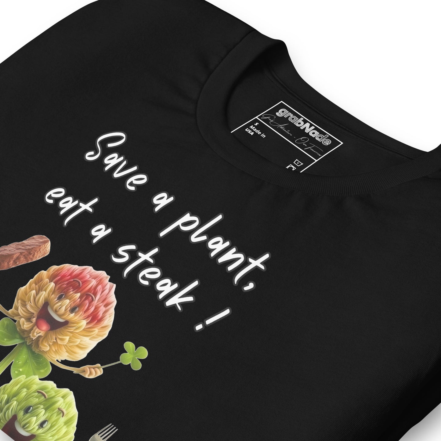 Product mockup. Close-up of a black t-shirt with the words "Save a plant, eat a steak!" and two cartoon flower characters holding utensils and a steak.