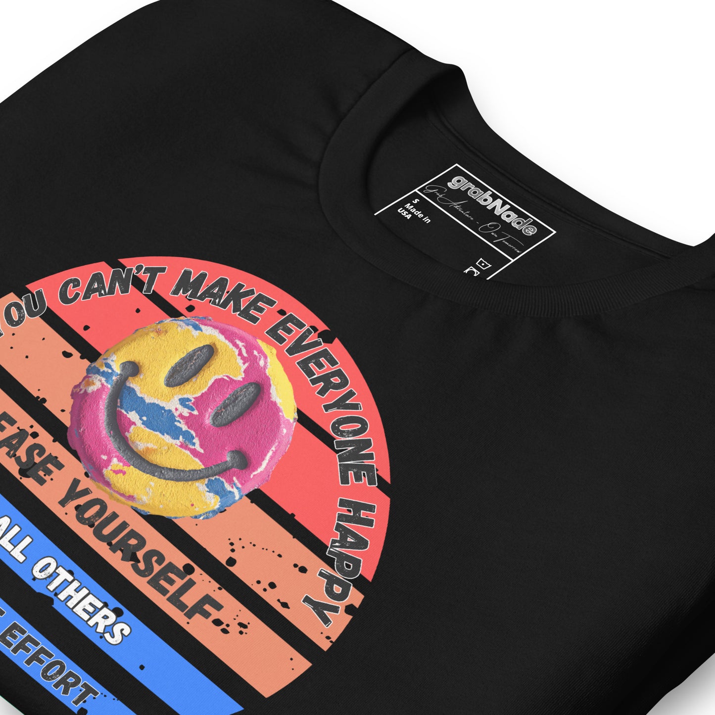 Product mockup. Close-up of a black t-shirt with a retro sunset background and text "YOU CAN'T MAKE EVERYONE HAPPY..." around a multicolored smiley face.