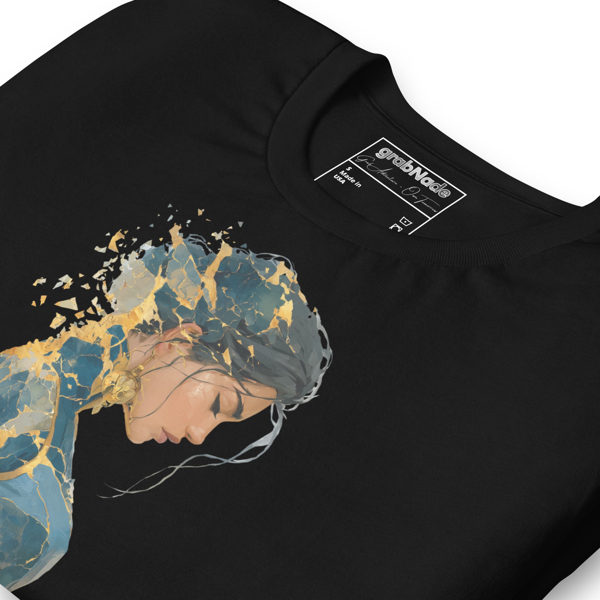 Product mockup. Close-up of a black t-shirt featuring a portrait of a woman with blue and gold fragmented effects across her hair and body.
