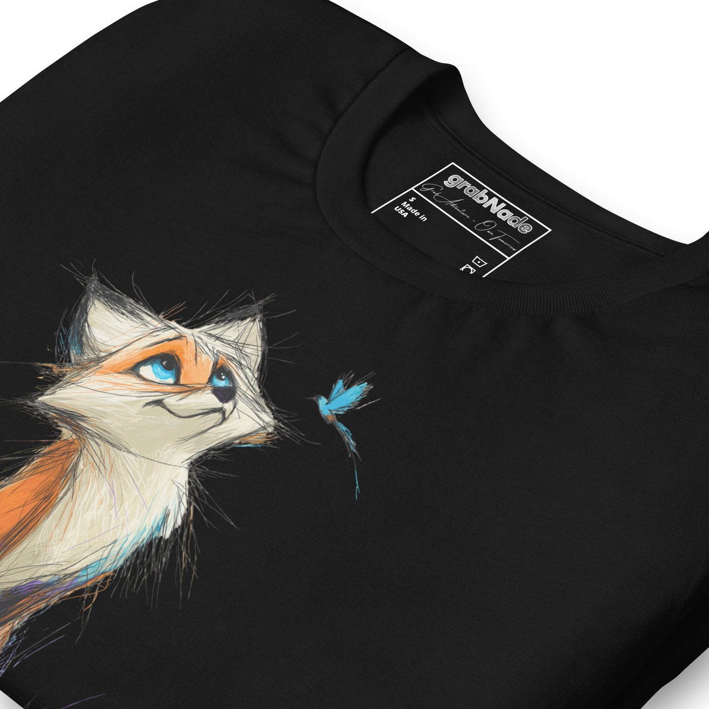 Product mockup. Close-up of a black t-shirt featuring a whimsical orange and white fox gazing at a blue butterfly illustration.