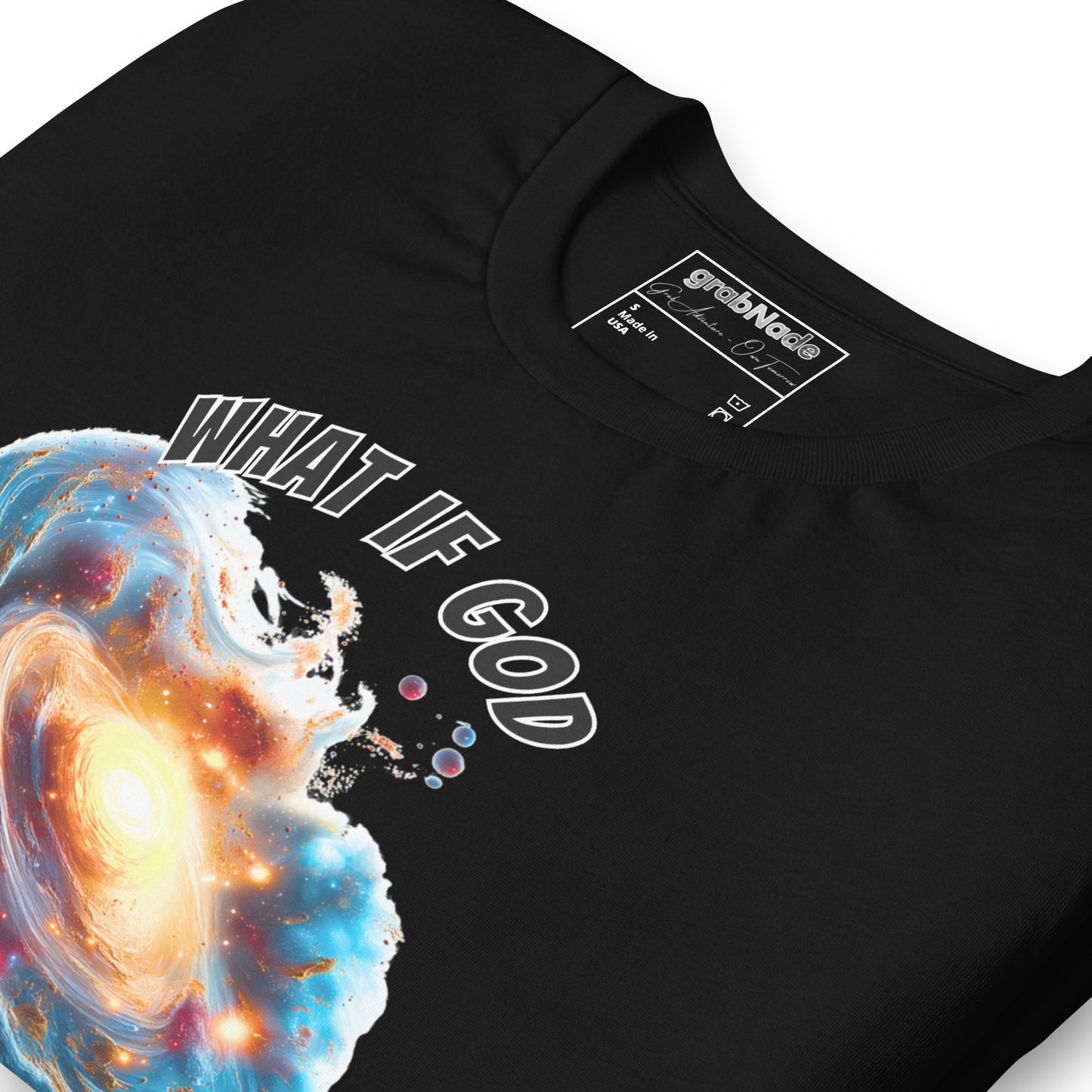 Product mockup. Close-up of a black t-shirt featuring a swirling cosmic galaxy graphic and the words "WHAT IF GOD."