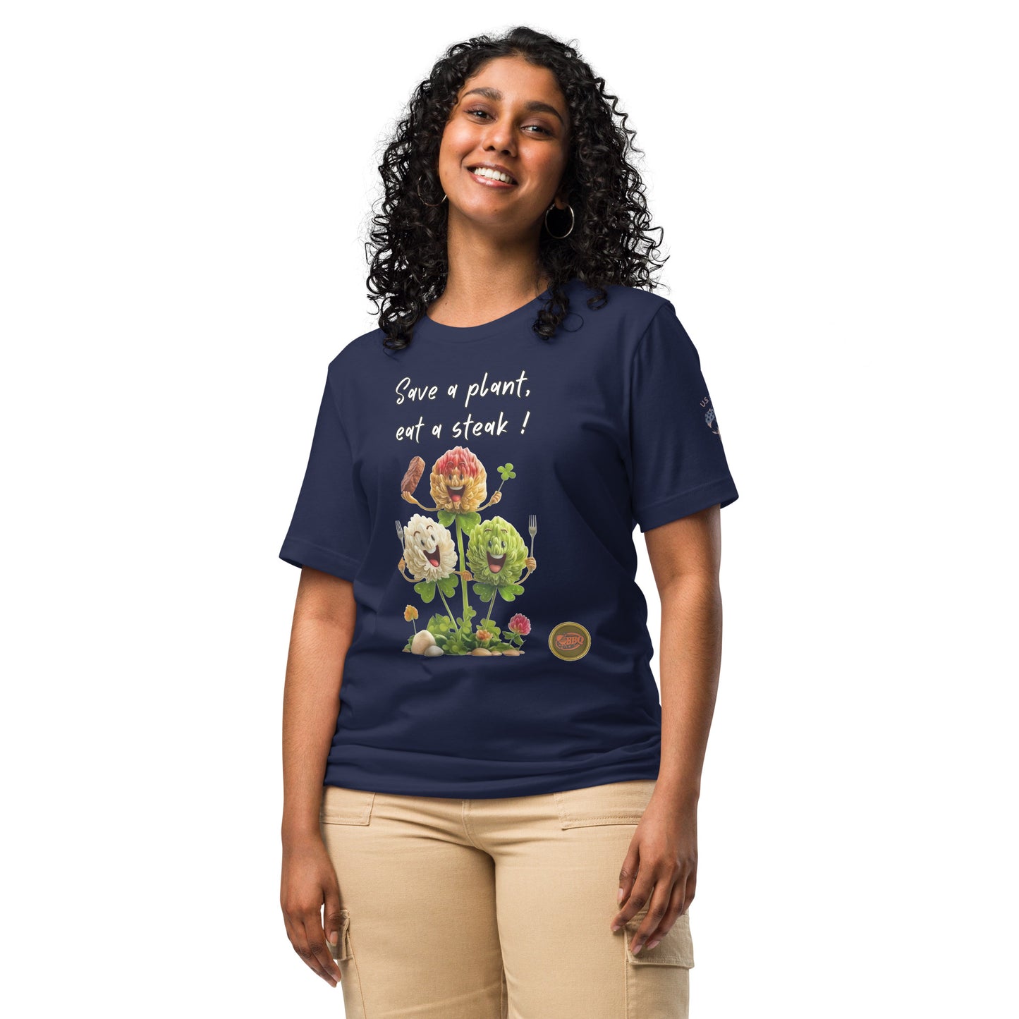 Product mockup. A woman stands wearing a navy blue t-shirt with "Save a plant, eat a steak!" written above a cartoon image of three cheerful flowers holding utensils and steak.