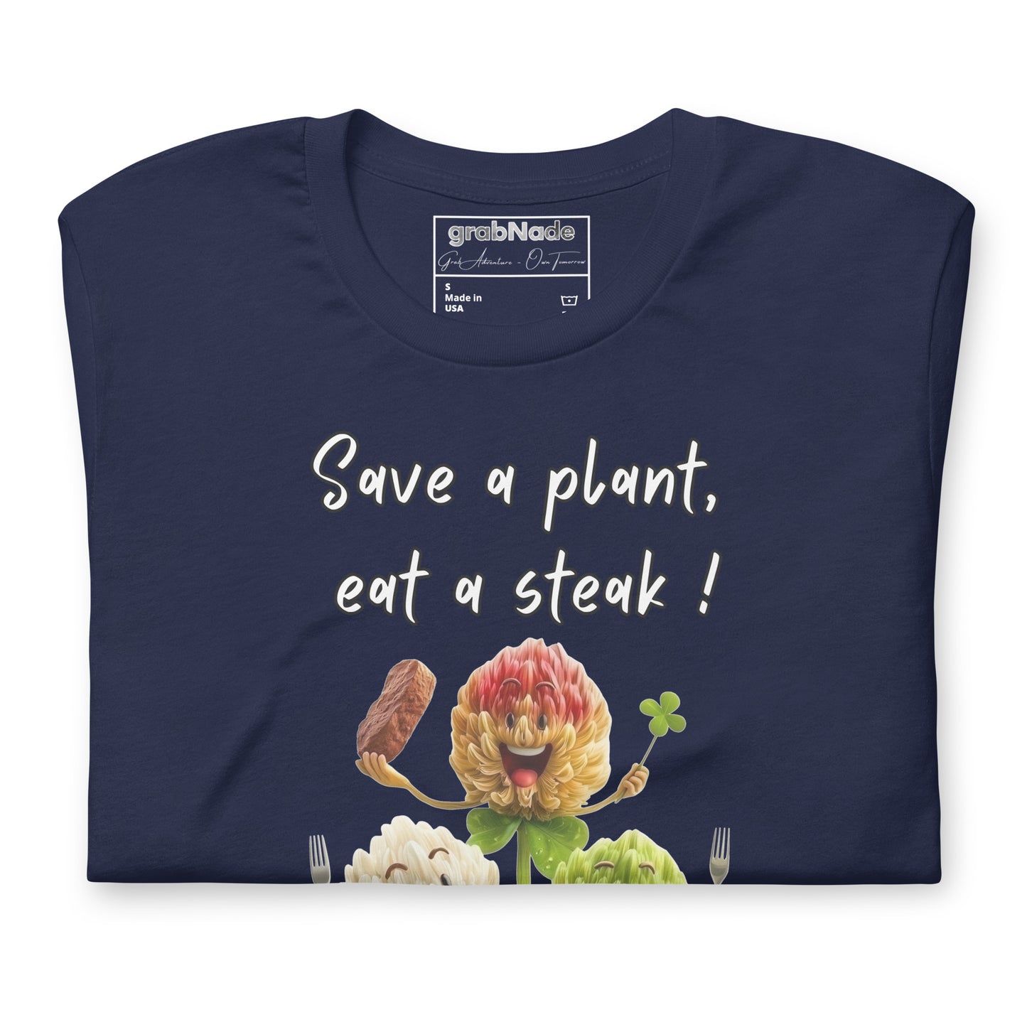 Product mockup. Navy blue t-shirt neatly folded, showing the top part of three smiling cartoon flowers and the text “Save a plant, eat a steak!”.