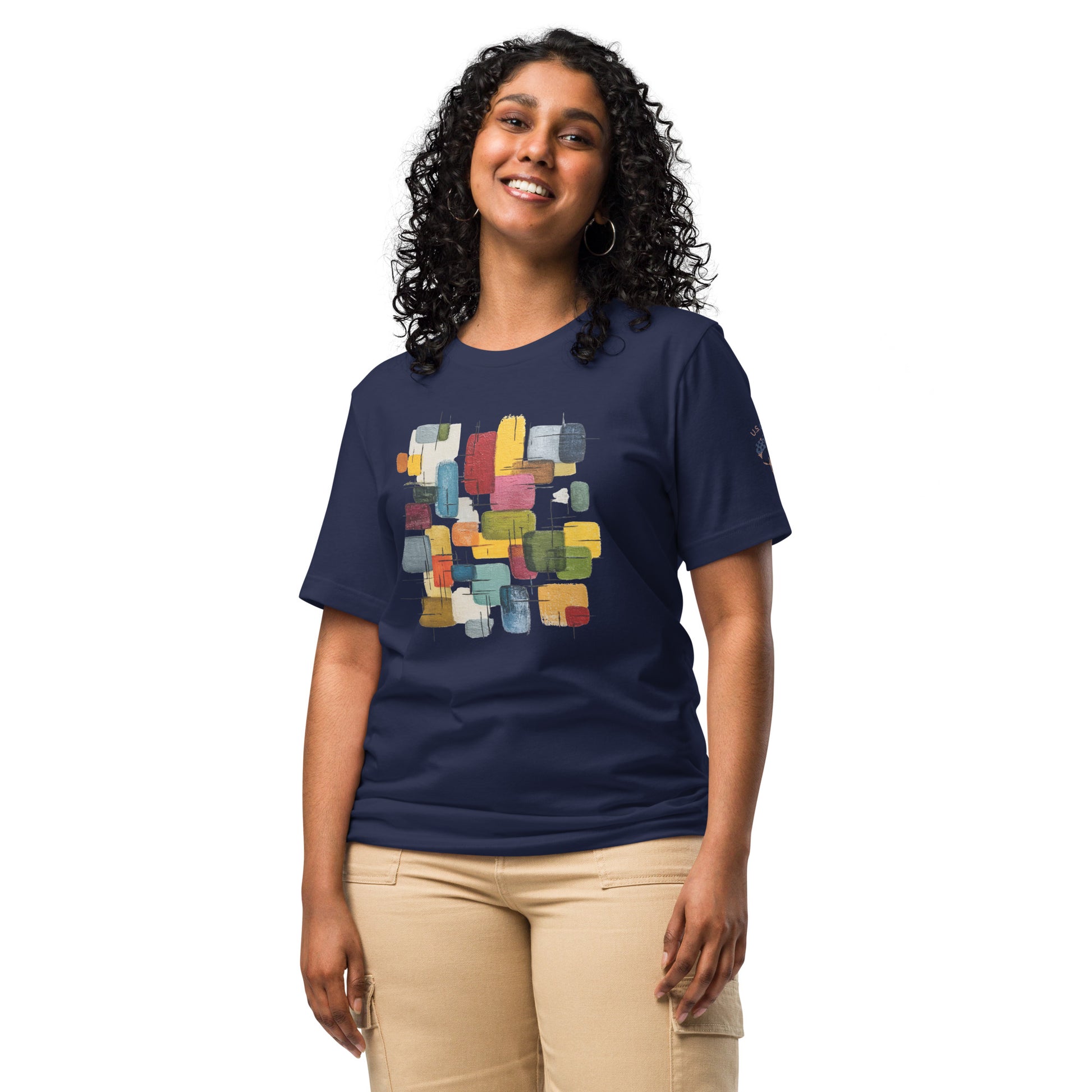 Product mockup. Smiling woman in beige pants wearing a navy blue t-shirt with a colorful geometric rectangular block pattern in the center.