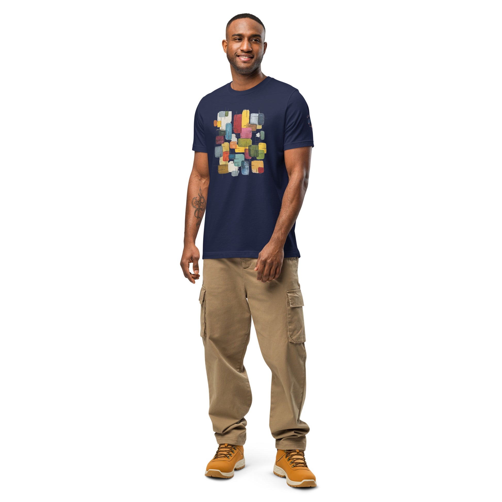 Product mockup. Smiling man in beige cargo pants and yellow boots, wearing a navy blue t-shirt with a geometrical abstract block pattern.
