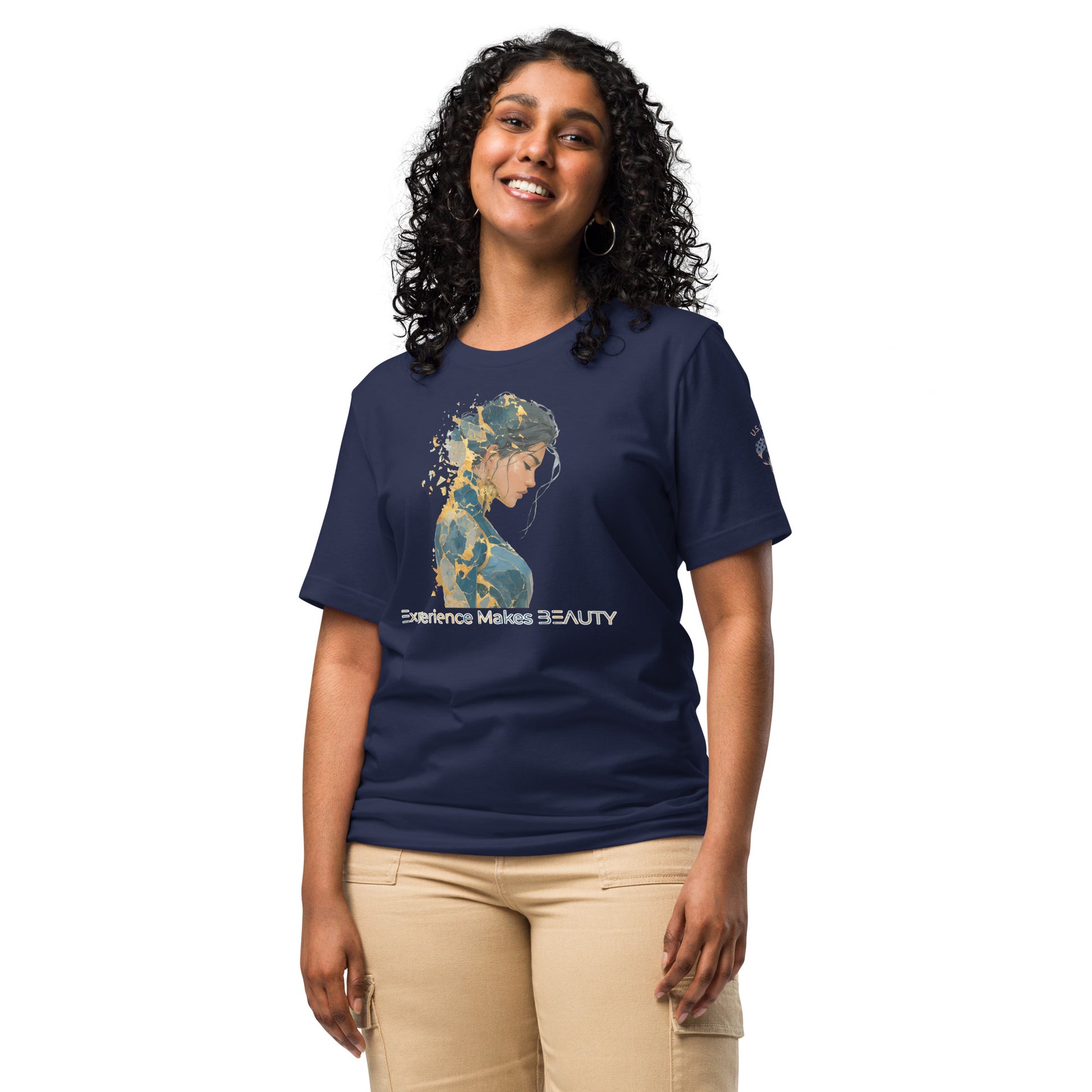 Product mockup. Smiling woman in beige pants and navy blue t-shirt with a gold and blue painted portrait of a woman, and the phrase “Experience Makes BEAUTY”.