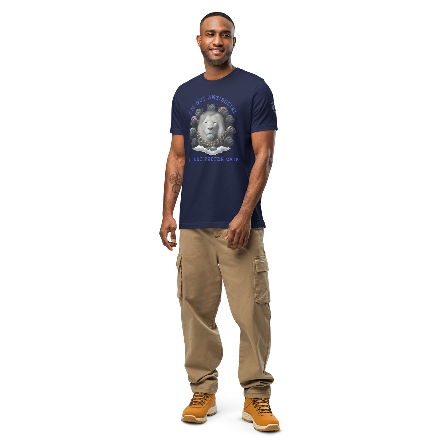 Product mockup. Man in tan cargo pants and boots, wearing a navy blue T-shirt with a gray lion's head surrounded by black cats and the text “I’m Not Antisocial I Just Prefer Cats.”