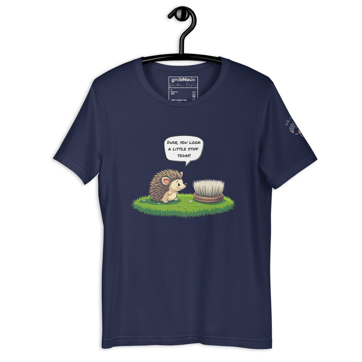 Product mockup. Navy blue t-shirt on a hanger, showing a cartoon hedgehog and brush with grass, speech bubble: “DUDE, YOU LOOK A LITTLE STIFF TODAY!”