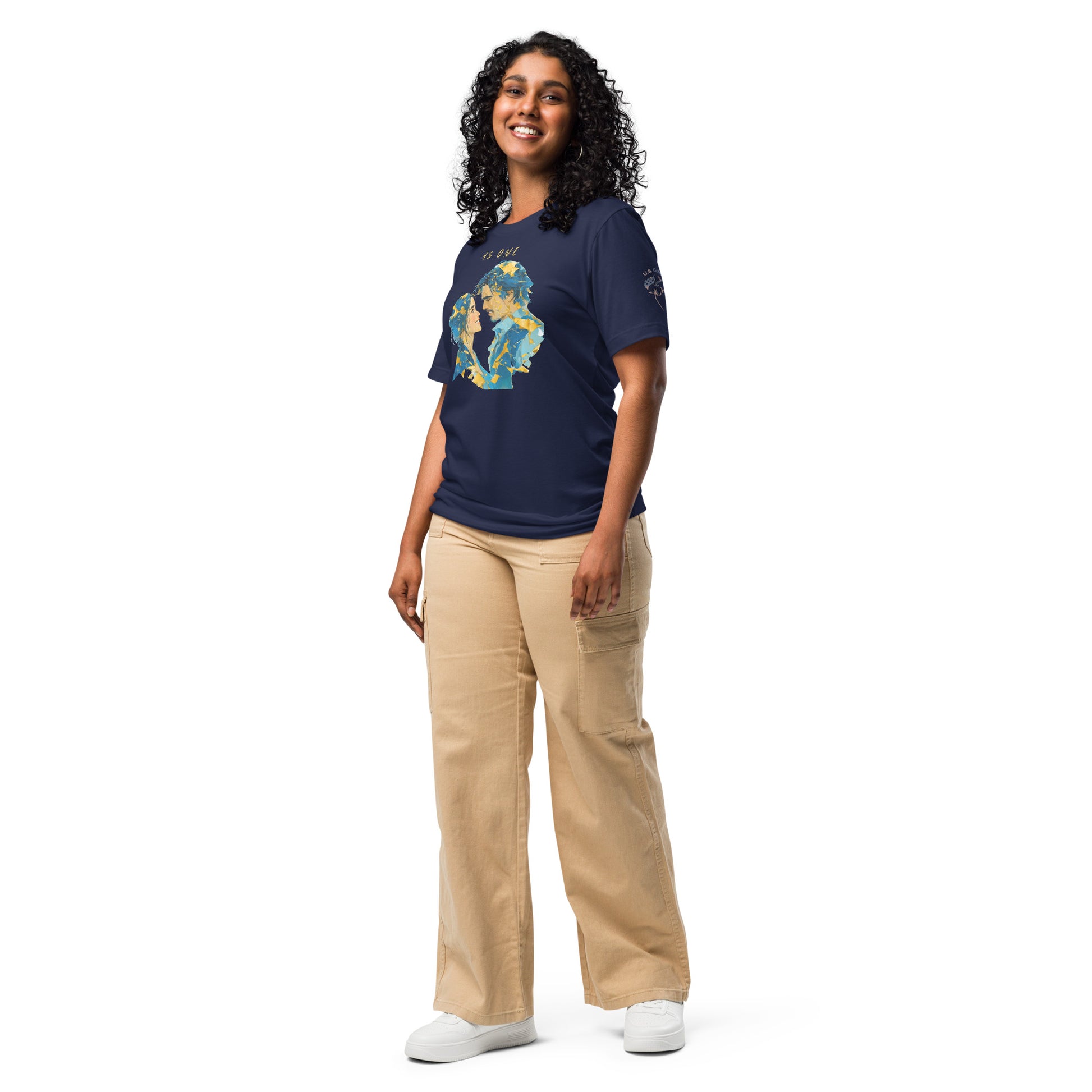 Product mockup. Smiling woman standing, wearing a navy blue T-shirt with an abstract blue and gold couple's portrait and "AS ONE" above.