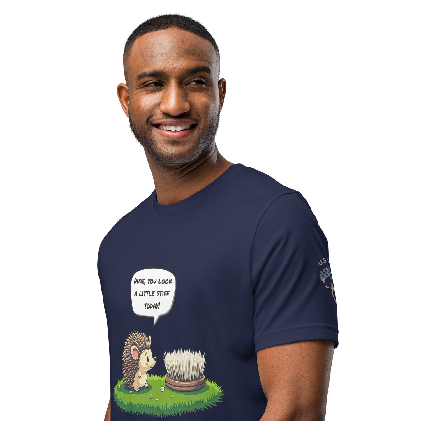 Product mockup. Smiling man wearing a navy blue T-shirt with a cartoon hedgehog addressing a round brush, with the speech bubble "DUDE, YOU LOOK A LITTLE STIFF TODAY!"