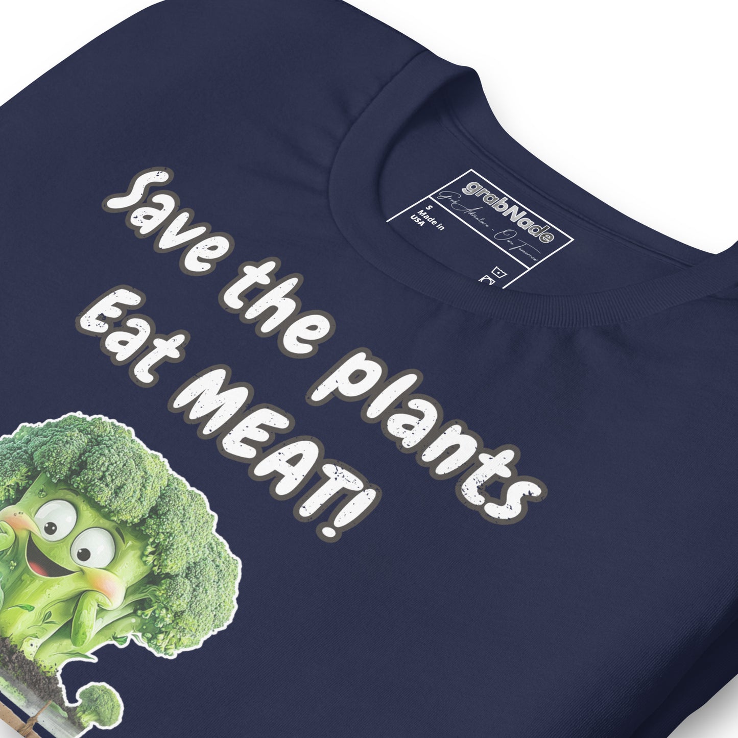 Product mockup. Close-up of navy blue T-shirt fabric displaying the slogan "Save the plants Eat MEAT!" with a smiling cartoon broccoli.