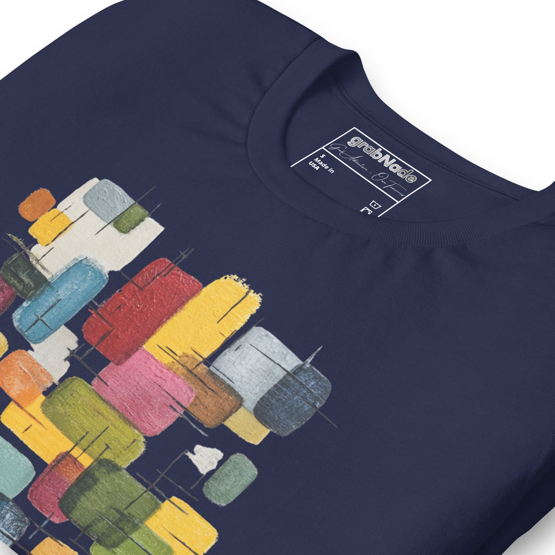 Product mockup. Close-up of navy blue T-shirt featuring a multicolor abstract block paint pattern.