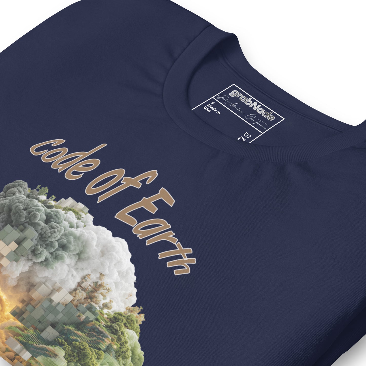 Product mockup. Close-up of navy blue T-shirt displaying a detailed "Code of Earth" nature and cloud graphic with pixelated accents.