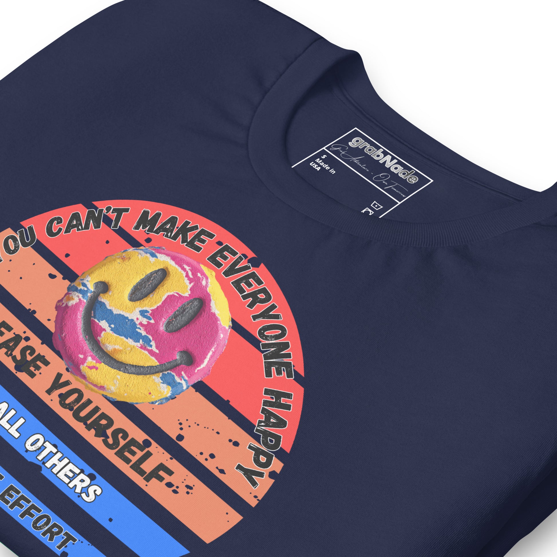 Product mockup. Close-up of navy blue T-shirt featuring a distressed smiley face on rainbow stripes with motivational text.