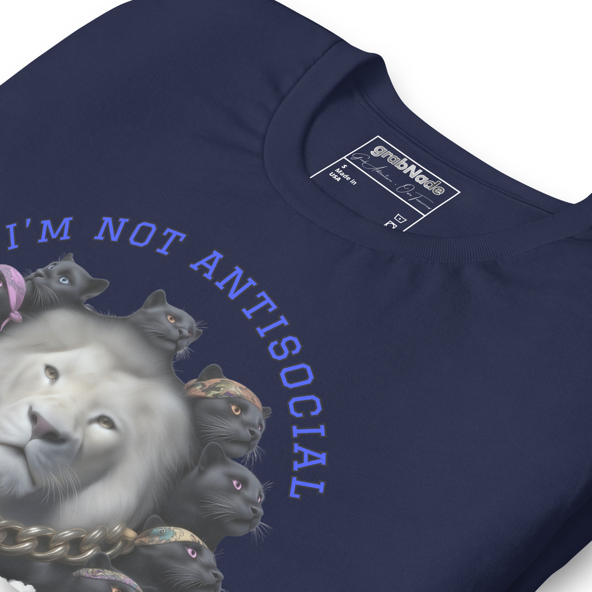 Product mockup. Close-up of navy blue T-shirt featuring a white lion surrounded by black panther heads, gold chain, text "I'M NOT ANTISOCIAL."