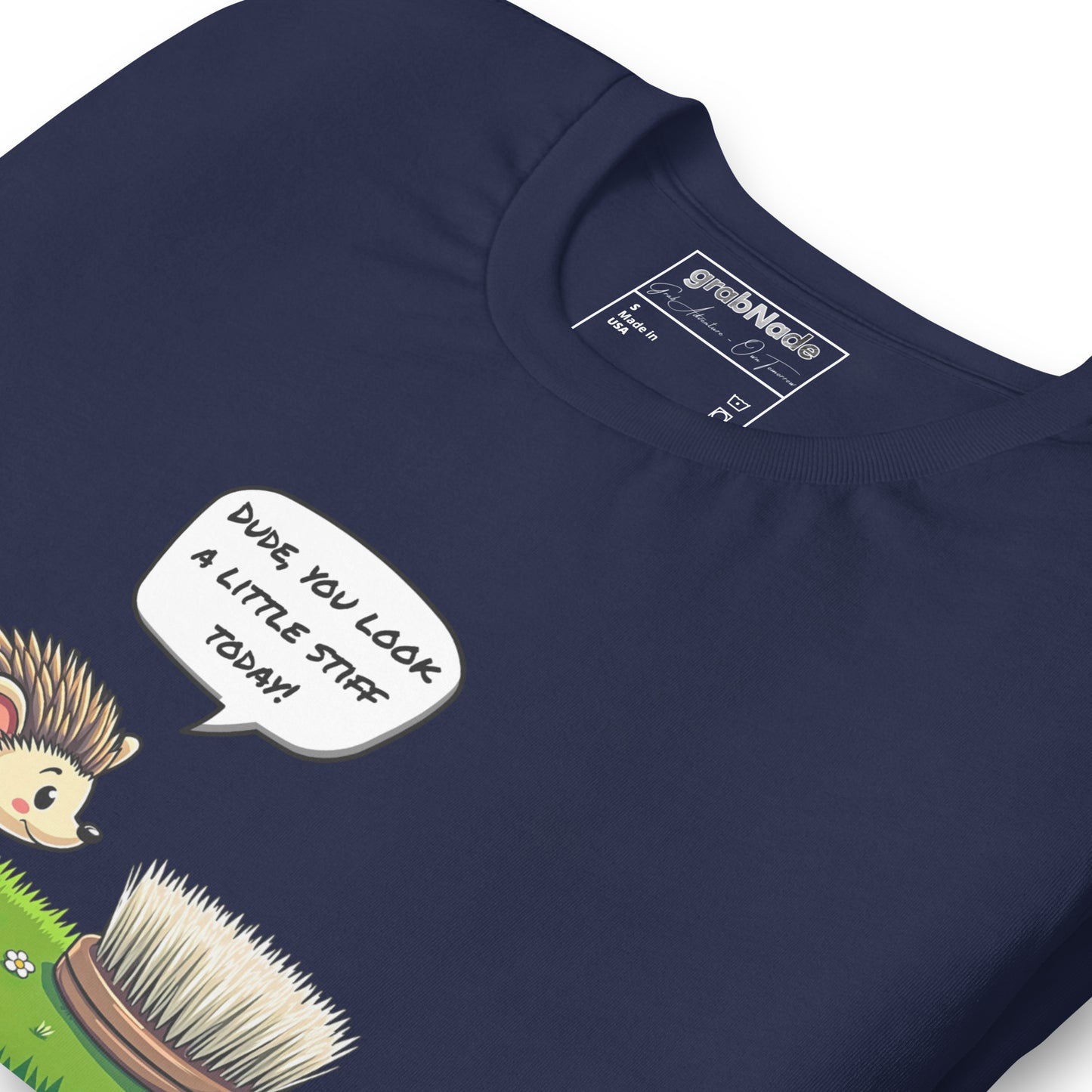 Product mockup. Close-up of navy blue T-shirt with a cartoon hedgehog and a speech bubble: "DUDE, YOU LOOK A LITTLE STIFF TODAY!"