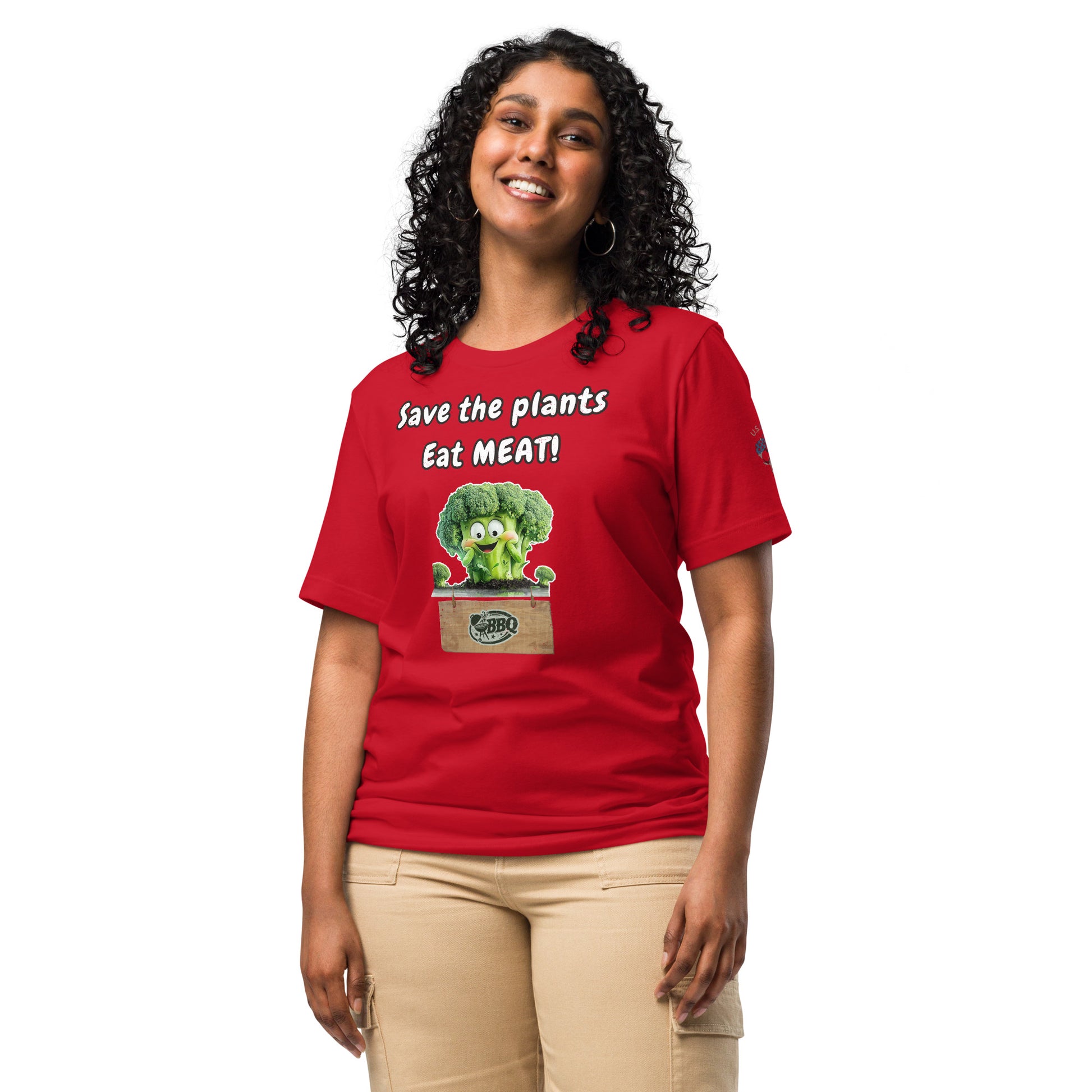 Product mockup. Smiling woman wearing a red T-shirt with a cartoon broccoli and the text "Save the plants Eat MEAT!" above a wooden BBQ crate.