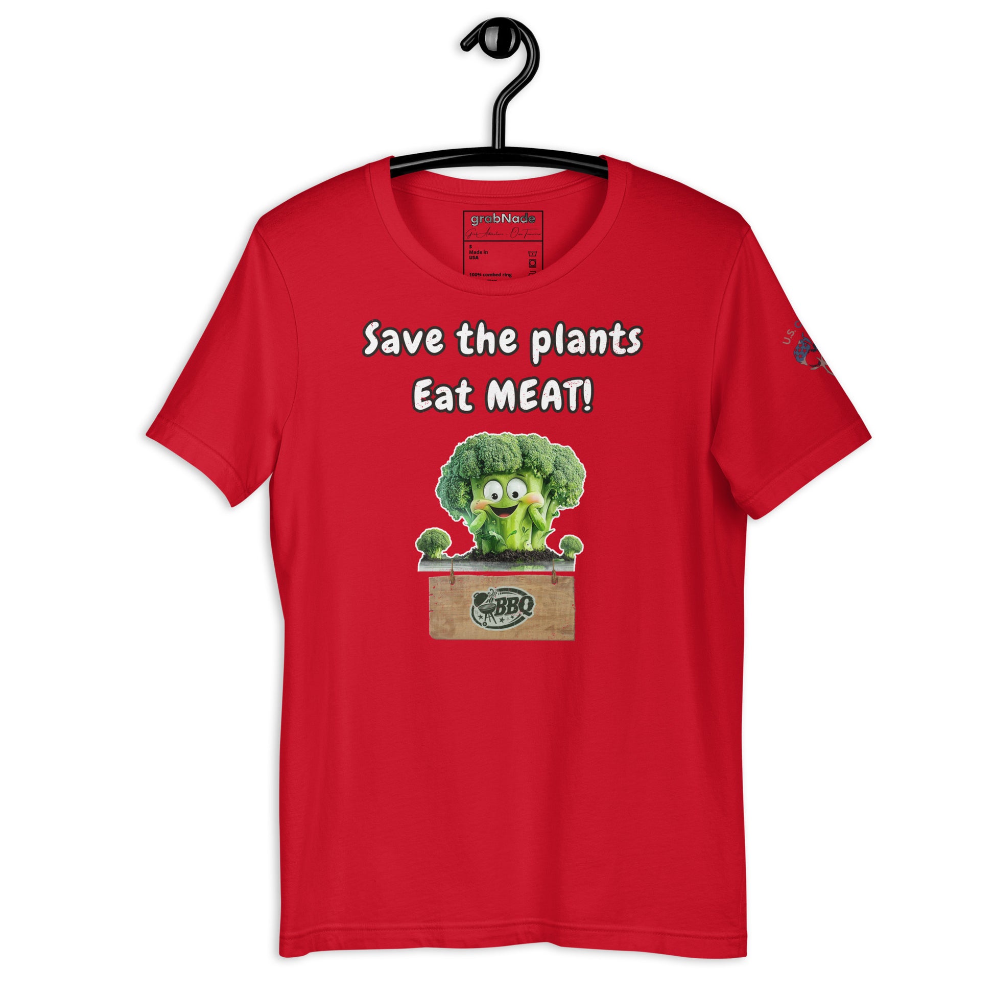 Product mockup. Red T-shirt on hanger featuring cartoon broccoli with "Save the plants Eat MEAT!" and a BBQ crate.