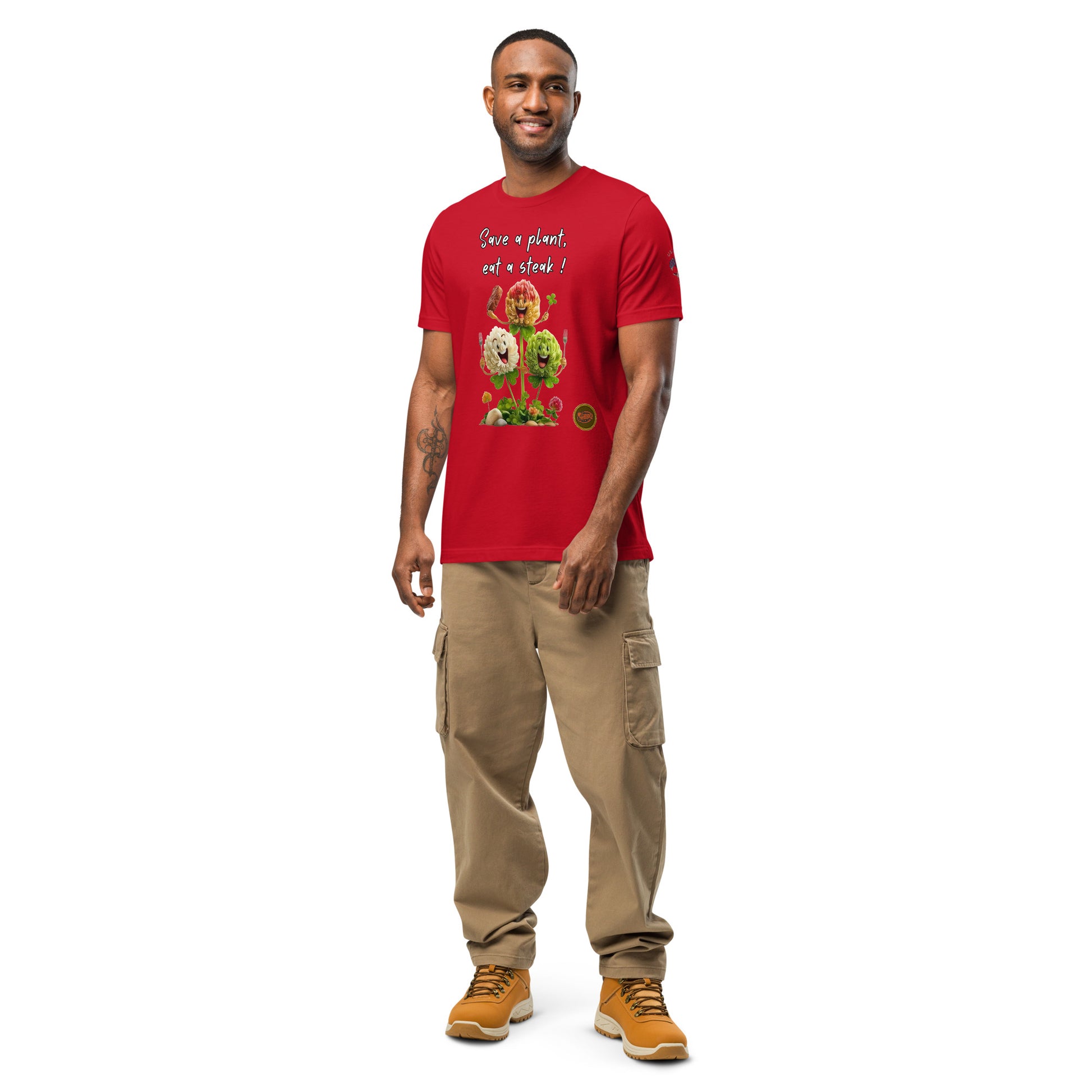 Product mockup. Man standing and smiling in a red T-shirt featuring "Save a plant, eat a steak!" text and smiling clover graphics.